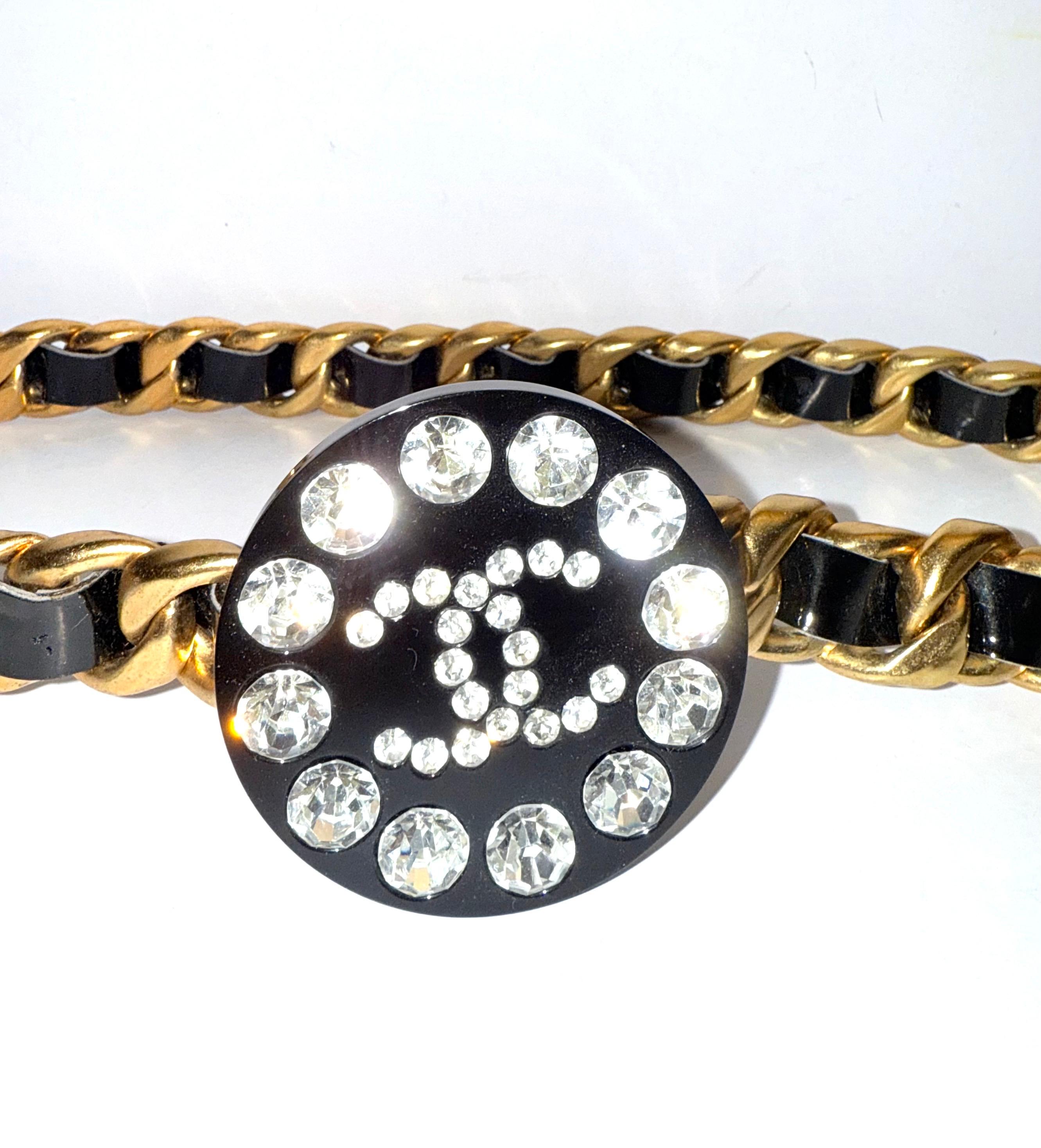 
Iconic Chanel black patent gold plated chain belt from 1995 collection.

CC rhinestone embellishment. 

Hook fastening.

 Length: 28 inches long. 1 inch width. 2.5 inches buckle diameter. 