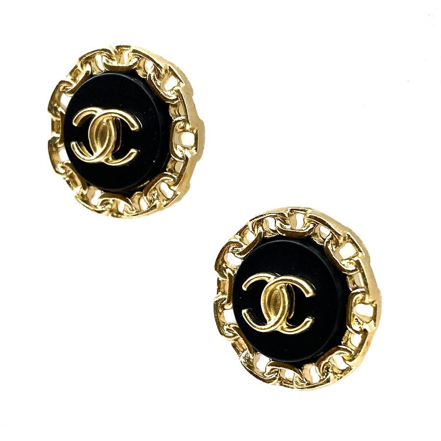 The stud earrings are from Maison CHANEL. They represent a round shape whose outline represents a CHANEL-style chain gilded in pale gold. They feature the famous CC emblem of the brand in their center on a black background.
The stud were never worn.