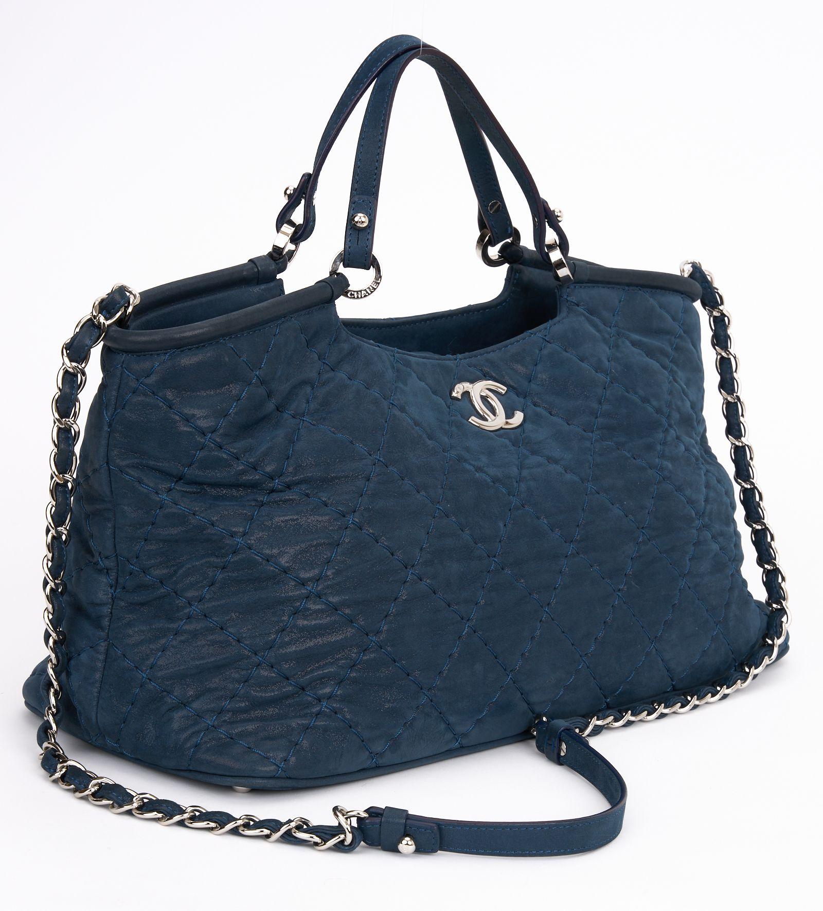 This Chanel CC Sea Hit Tote Quilted Iridescent Calfskin is a stylish tote and an ideal everyday bag. Features navy quilted iridescent calfskin, leather strap top handles, leather shoulder strap with woven-in leather chain detail, silver-tone Chanel