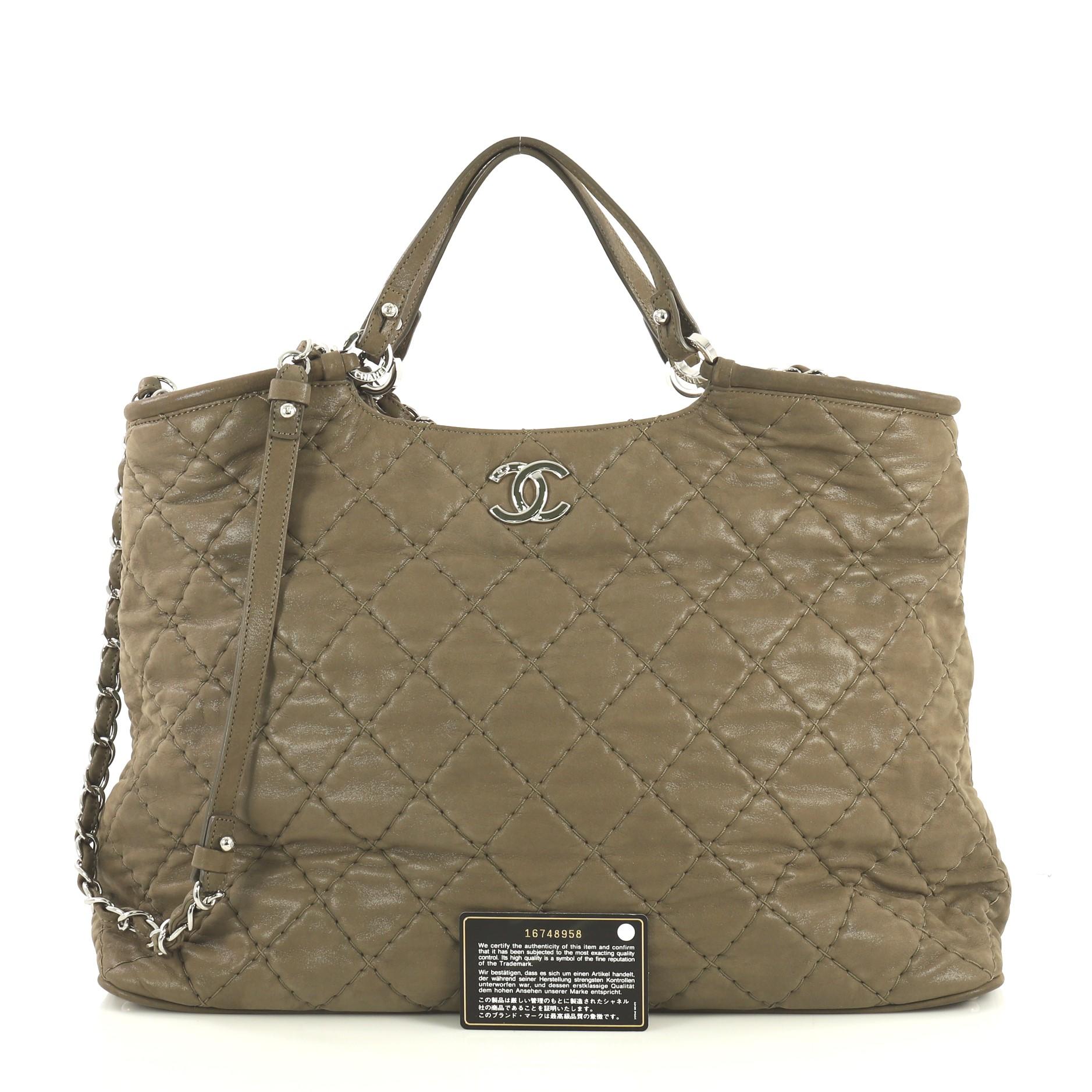 This Chanel CC Sea Hit Tote Quilted Iridescent Calfskin Large, crafted in neutral quilted iridescent calfskin leather, features dual slim leather handles, woven-in leather chain link straps with shoulder pads and silver-tone hardware. Its magnetic