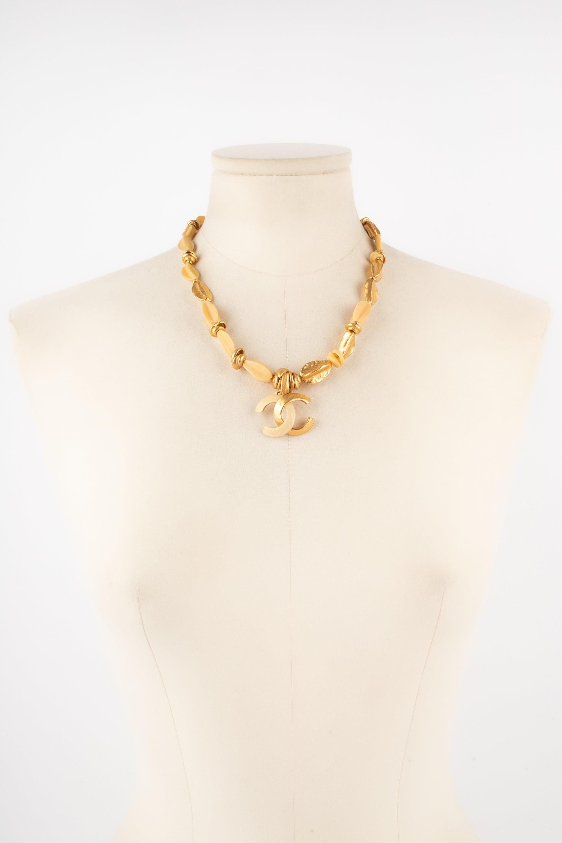 Chanel - (Made in France) Short golden metal and resin necklace centered with a cc pendant. 2000 Collection.

Additional information:
Condition: Very good condition
Dimensions: Length: From 46 cm to 49 cm
Period: 21st Century

Seller Reference: CB278