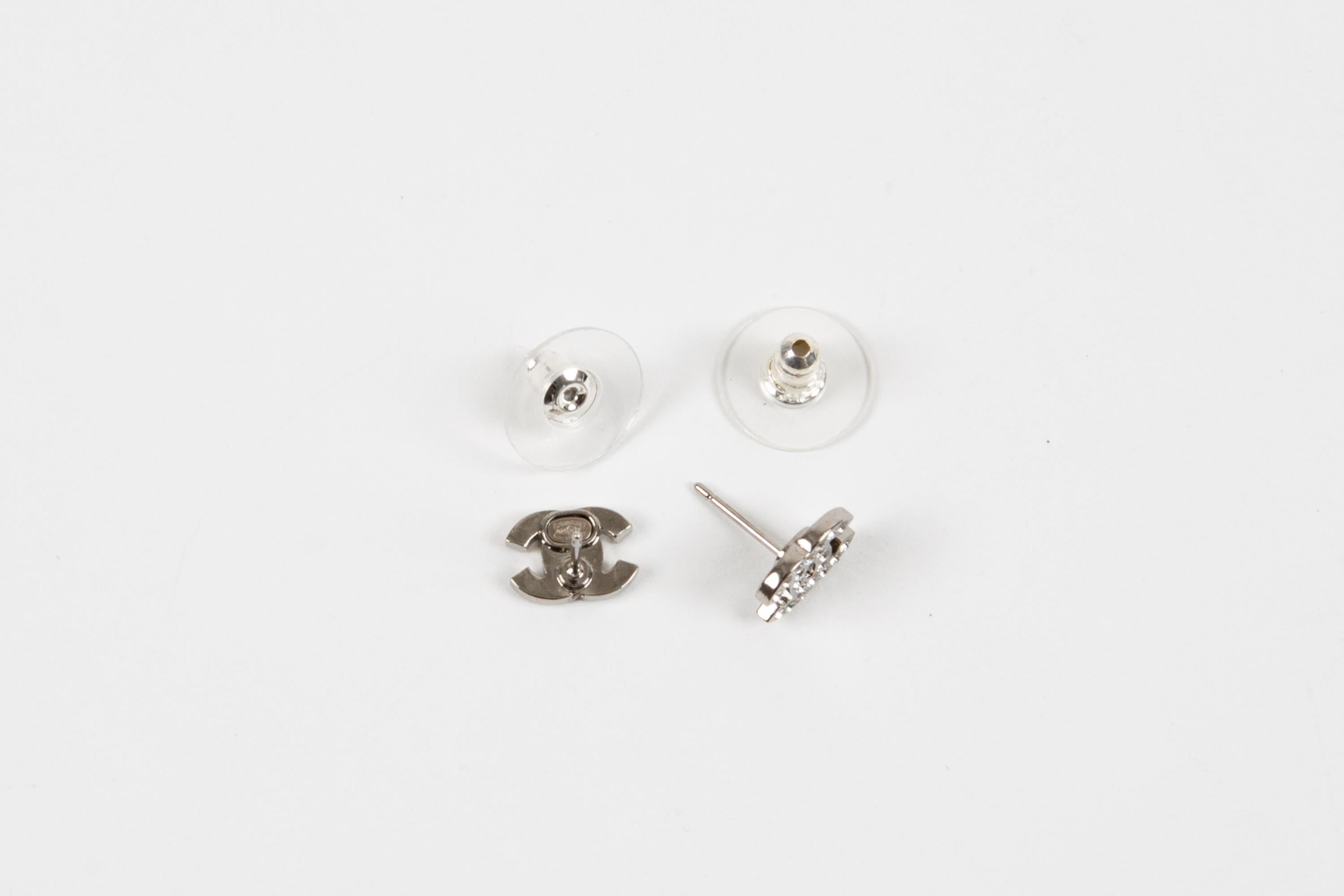 Chanel CC silver-tone mini “CC” earrings featuring crystal embellishment, a signature interlocking CC logo, back plaque pitted. They come as a pair. 
Circa 2010s  Made in France
Width:  0.39in (1cm)
Excellent vintage condition. Made in France. 