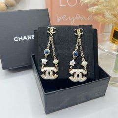 Boucles d'oreilles pendantes Chanel CC Star avec breloque en résine