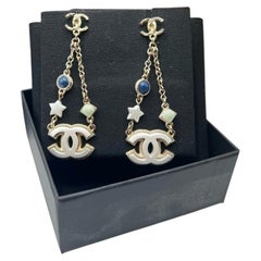 Boucles d'oreilles pendantes Chanel CC Star avec breloque en résine