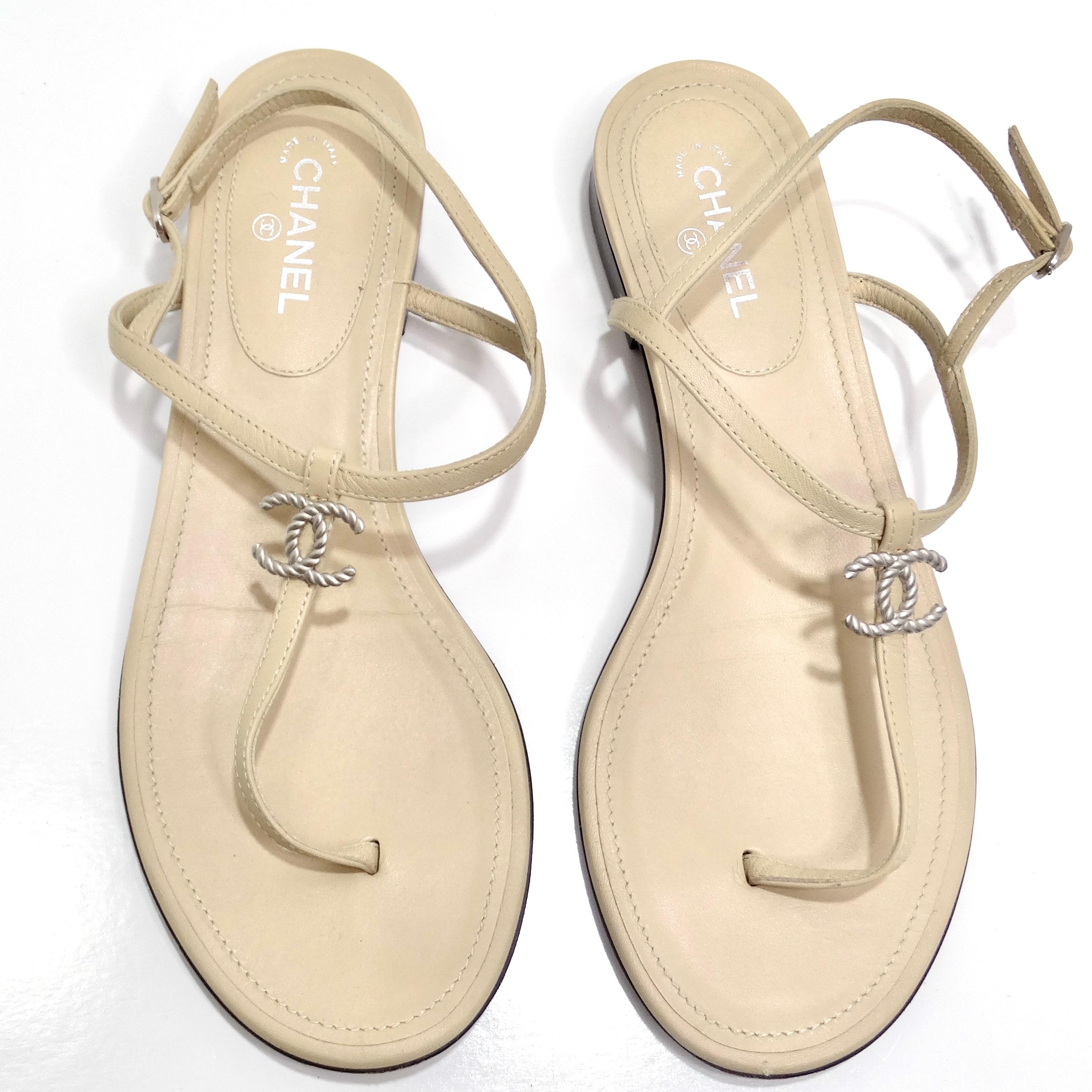 Découvrez l'élégance intemporelle des sandales en cuir Chanel CC T Strap, un ajout classique et polyvalent à votre collection de chaussures. Confectionnées dans un luxueux cuir beige, ces sandales à lanières présentent un design en forme de T qui
