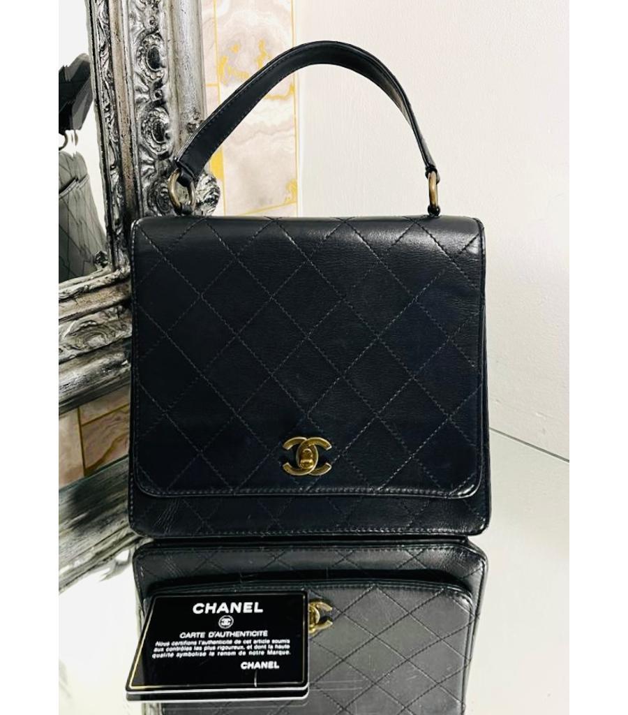 Chanel 'CC' Turn-Lock Vintage Leather Bag

Black, structured handbag designed with signature diamond quilting and aged gold interlocking 'CC' logo turn-lock closure.

Featuring front flap leading to leather interior with zip and slit pockets and