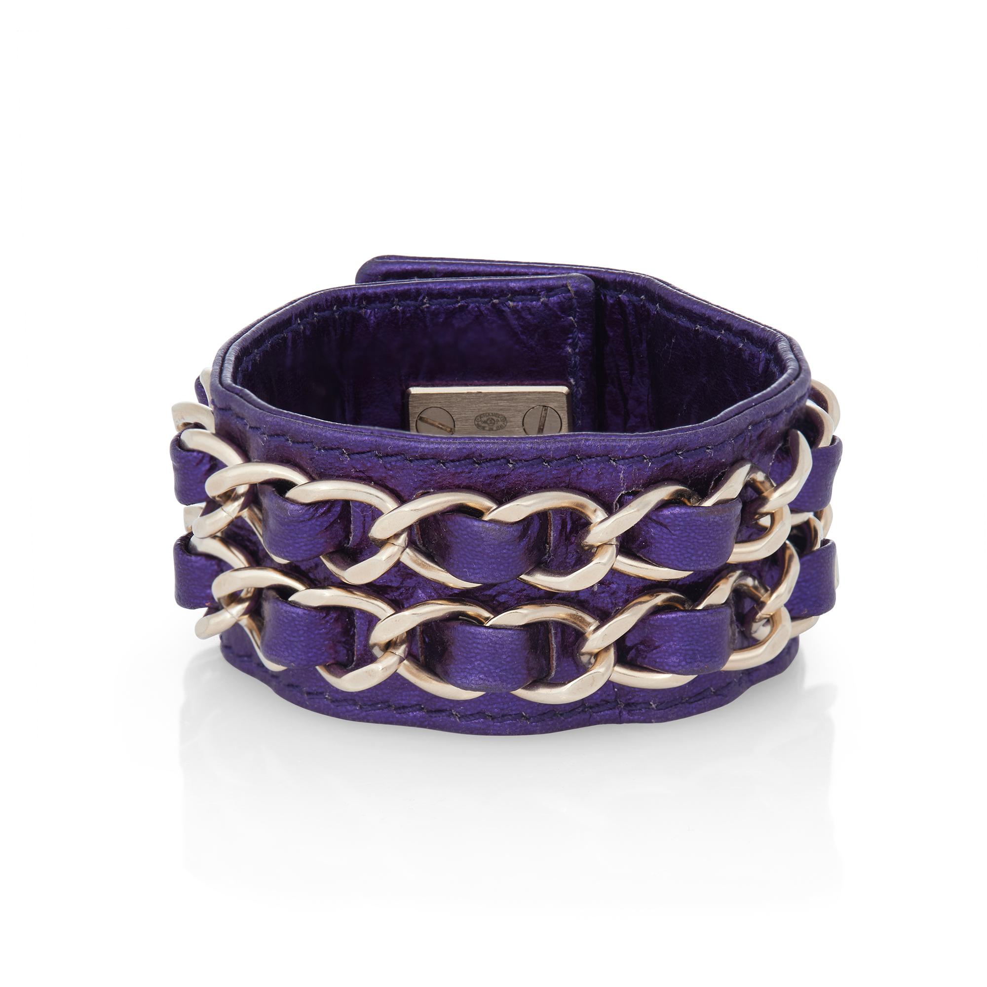 Authentic Chanel bracelet crafted in metallic purple leather and featuring silvertone chain detail.  The bracelet measures 8 inches in total length and 1.22 inches wide.  Bracelet is not presented with the original box or papers.  CIRCA