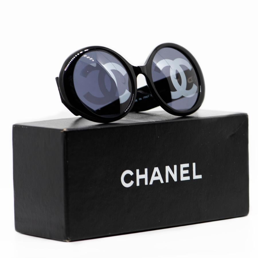 Original sunglasses from the Maison CHANEL. Black in color, the glasses are oval in shape and support round lenses on each is a large CC logo, covering almost all of the glass, but nevertheless comfortable for your eyesight. Each branch also has the