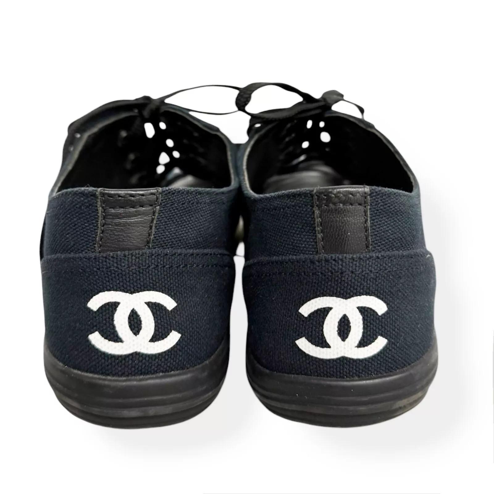 Chanel CC laced up sneaker in size European 40.5 , US 9.5

Color: Black with white line  
Material: Canvas
Year: 2016
Measurements:
Insole Length: 26 cm
Heel Height: Approximately 2 cm
Made In Italy
Ships from Canada