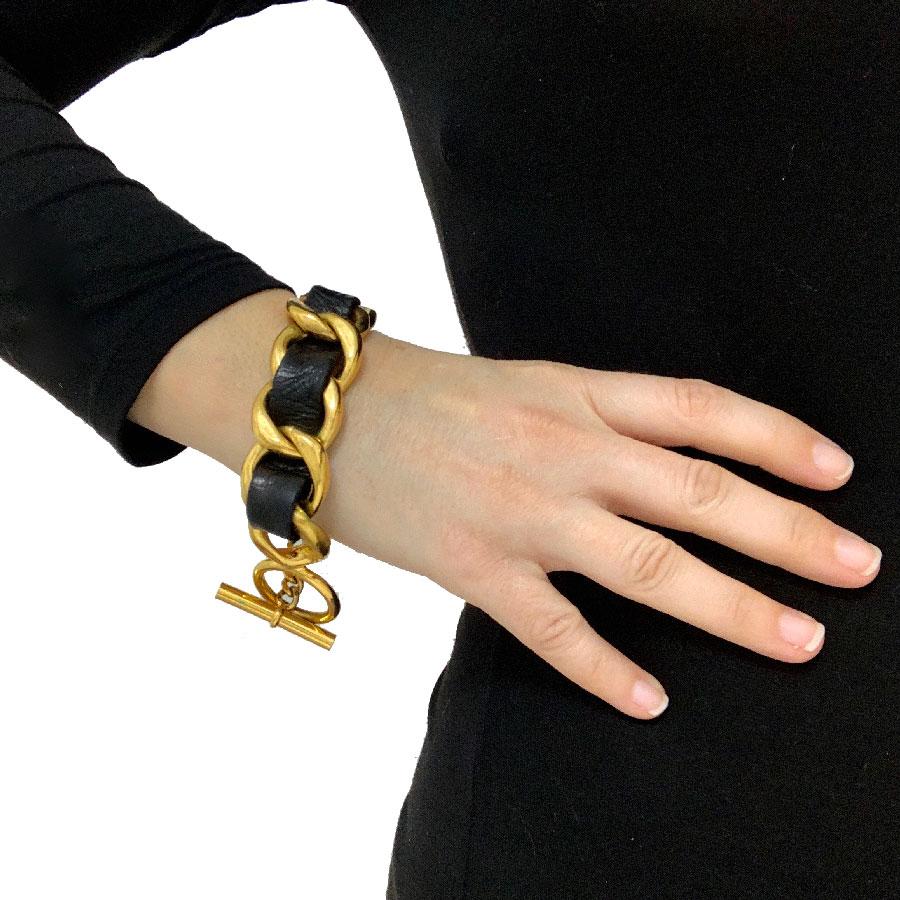 CHANEL chain bracelet in gilt metal interlaced with black calfskin leather. Clasp T. 

Collection of the 2000s. Made in France.
This bracelet is in very good condition. Small traces of oxidation but not visible when you wear it. The hall mark is