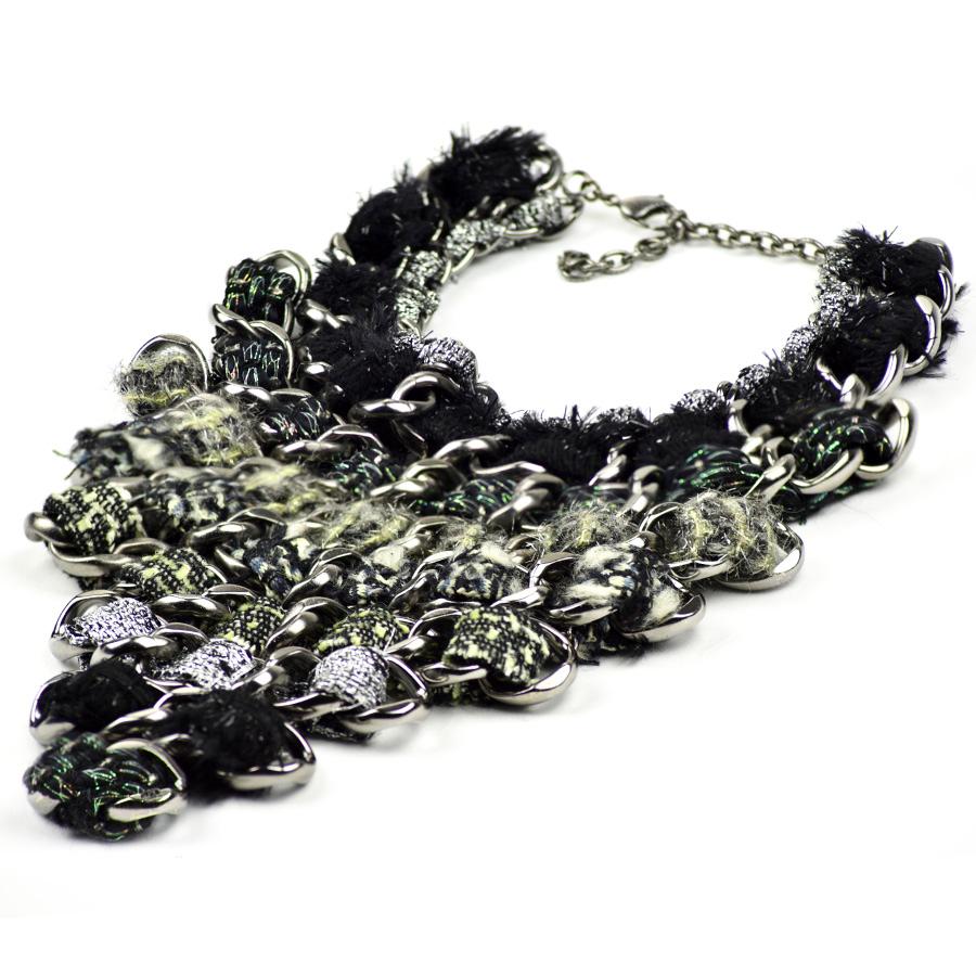 The breastplate comes from Maison CHANEL. Triangular in shape, it is made up of silver metal chains which intertwine tweed in shades of green, silver and black. This piece is from a fashion show.
In very good condition. Its neck is adjustable from