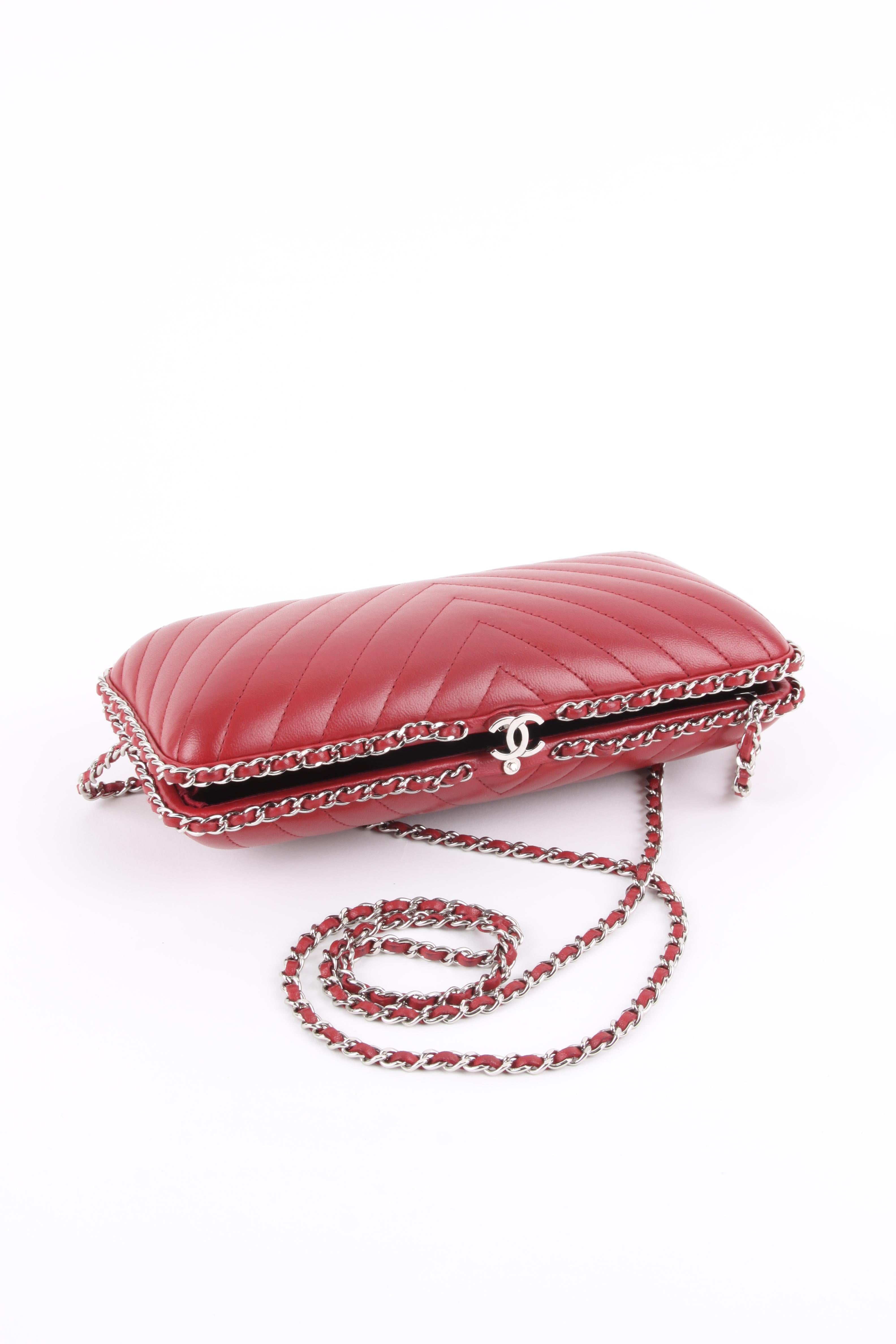 Wonderful evening bag by Chanel, this is the Chain Around Box Clutch.

Executed in warm red leather with Chevron-quilting on the front and back. Embellished with a silver-tone chain entwined with red leather. 

A CC lock on top, inside lining in