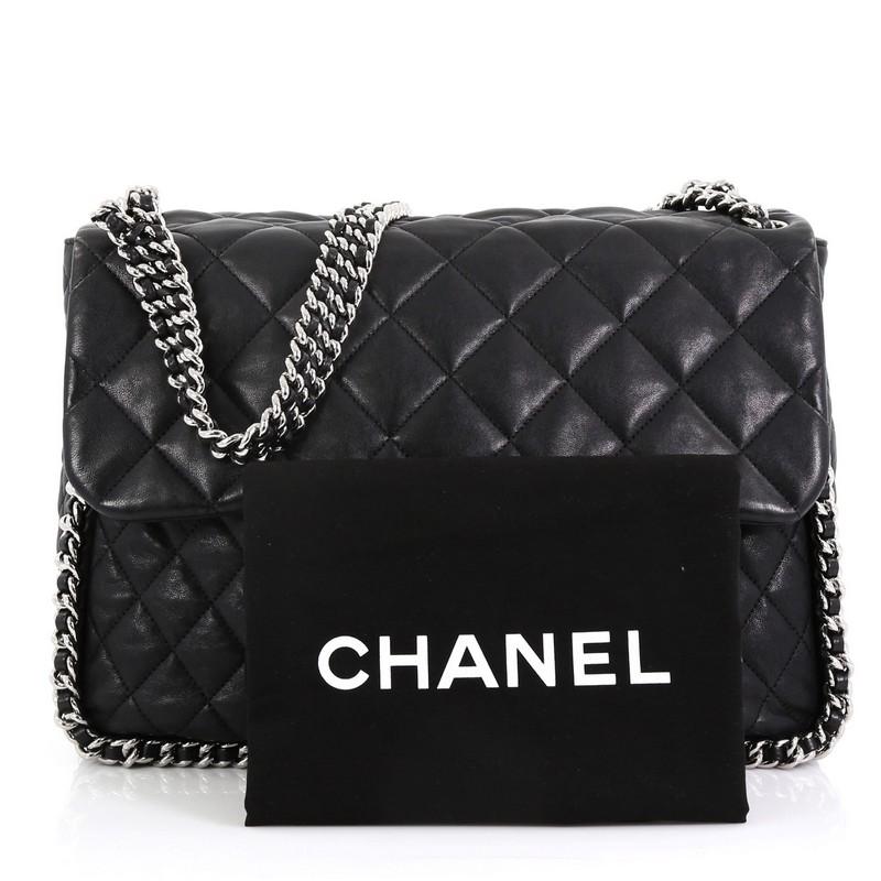 This Chanel Chain Around Flap Bag Quilted Leather Maxi, crafted in black quilted leather, features woven-in leather chain strap, chain-around design, frontal flap with CC logo, and silver-tone hardware. Its magnetic snap closure opens to a beige
