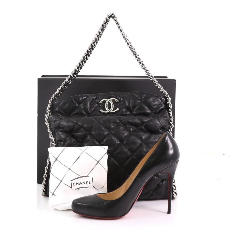 This Chanel Chain Around Hobo Quilted Washed Lambskin, crafted with black quilted washed lambskin, features silver woven-in leather chain straps wrapped around the bag, and silver-tone hardware. Its magnetic snap closure opens to a grey fabric