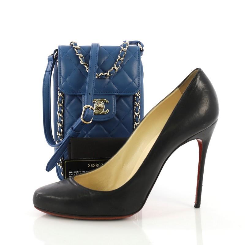 This Chanel Chain Around Phone Holder Crossbody Bag Quilted Lambskin, crafted in blue quilted lambskin leather, features woven-in leather chain strap, a flap top with CC turn-lock closure, woven-in leather chain trim, and gold-tone hardware. Its