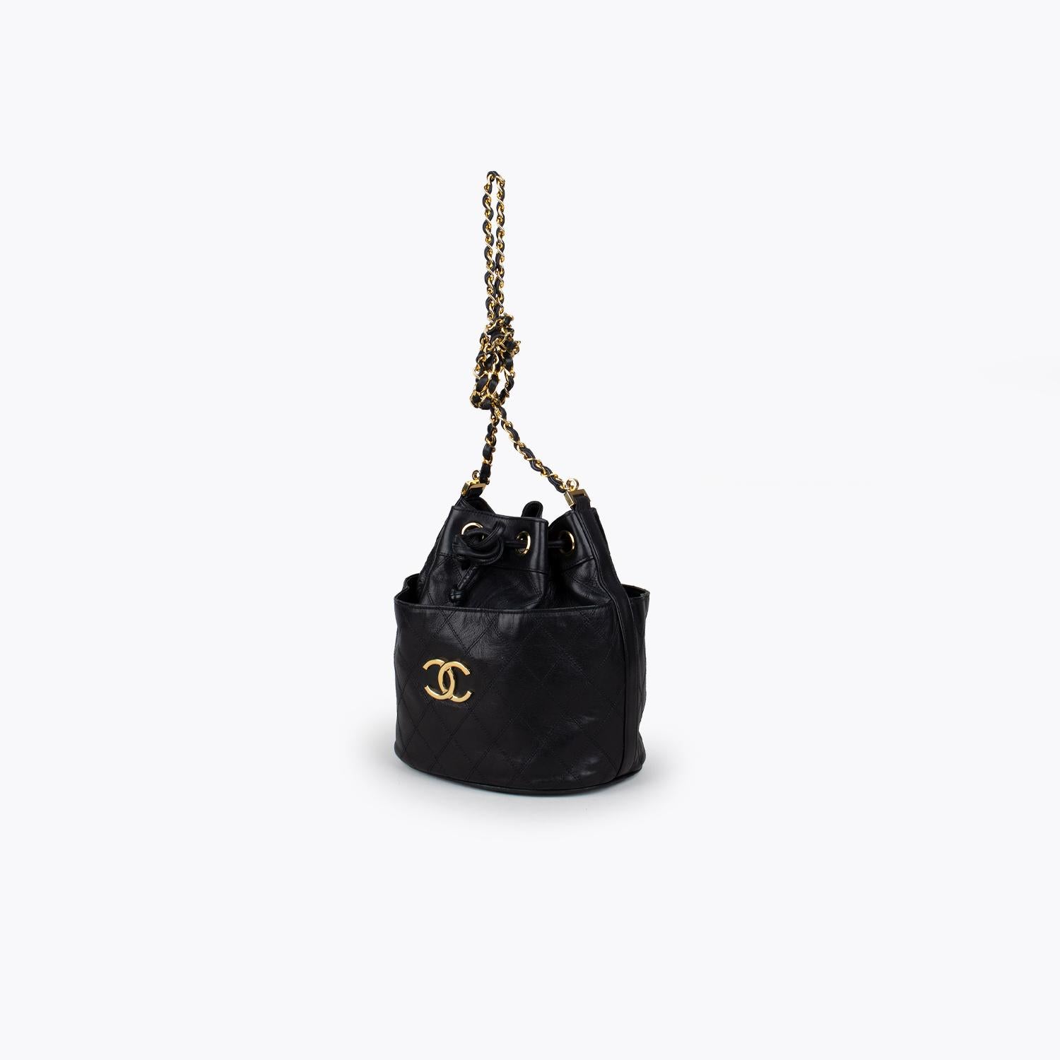 Black quilted lamb leather Chanel Chain bucket bag 

– Gold-tone hardware
– Single detachable chain-link shoulder strap
– Dual slit pockets at back and front
– Tonal leather lining and drawstring closure at top

Overall Preloved Condition: Very