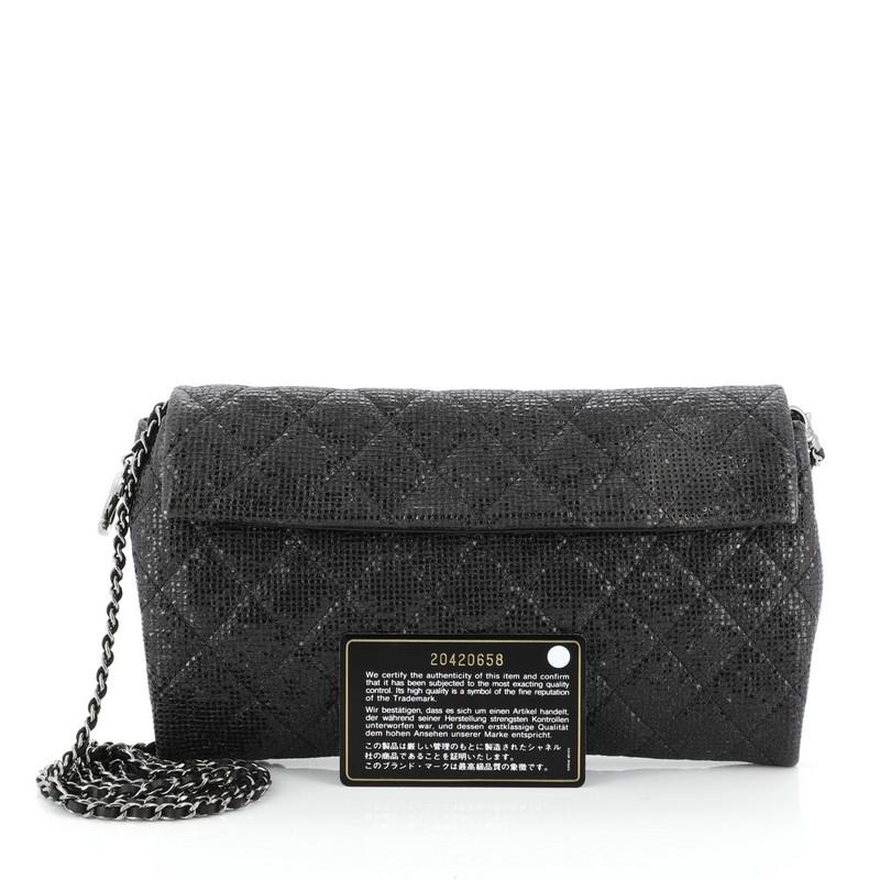 This Chanel Chain Clutch Quilted Glittered Calfskin, crafted in black quilted glittered calfskin, features woven-in leather chain strap and gunmetal-tone hardware. Its front flap with magnetic snap and zip closure opens to a black satin interior