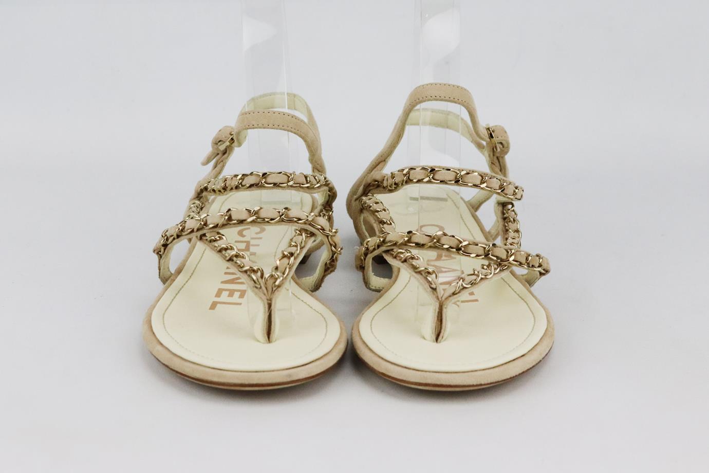 Sandalias Chanel de ante con detalle de cadena. De ante beige con detalle de cadena plateada en las tiras. Beige. Cierre de hebilla en el lateral. No viene con caja ni bolsa guardapolvo. Talla: EU 38 (UK 5, US 8). Plantilla: 9.5 pulg. Plataforma: