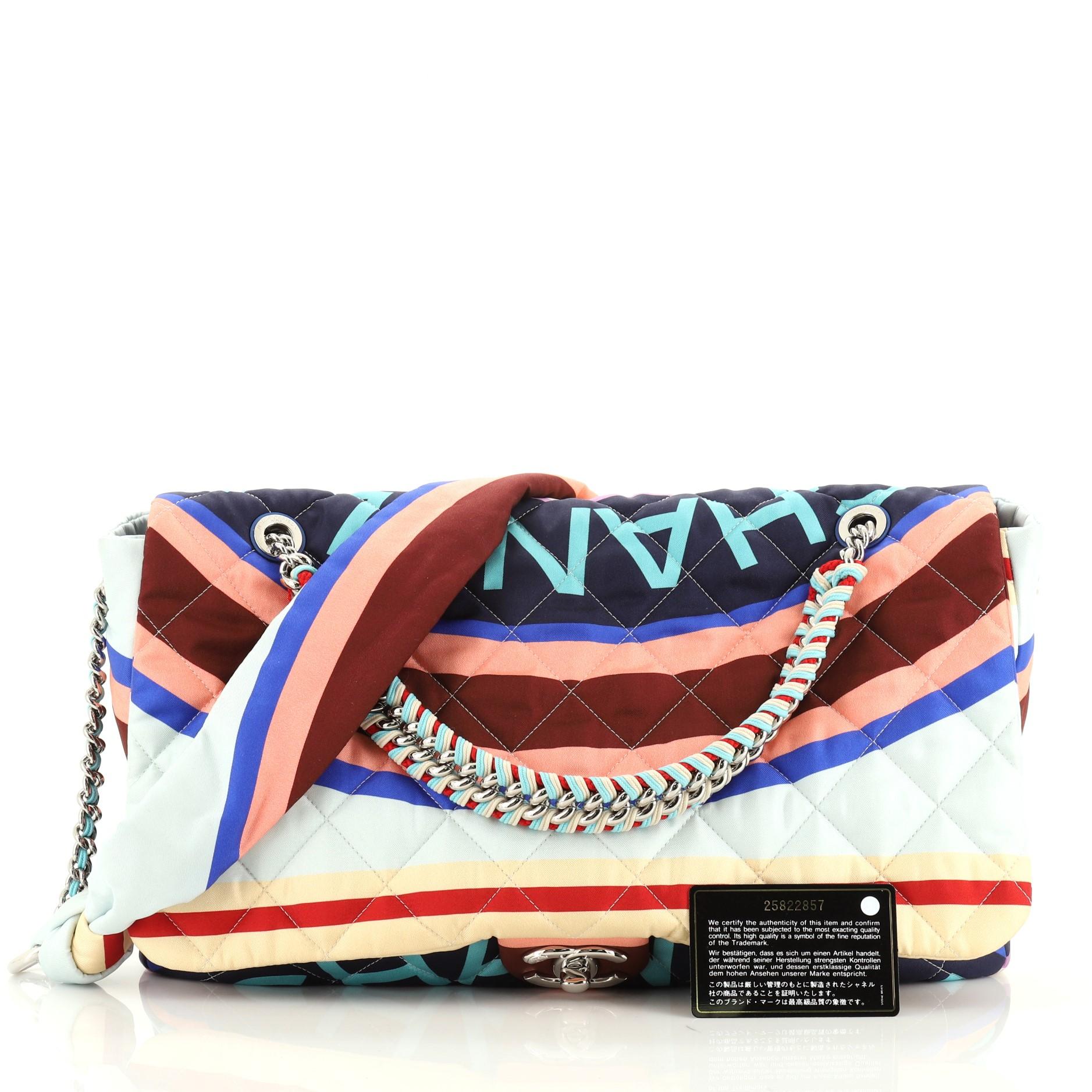 This Chanel Chain Flap Bag Quilted Printed Foulard Large, crafted in blue and multicolor printed quilted foulard, features multicolor woven chain handle, shoulder strap with chain and gunmetal-tone hardware. Its CC turn-lock closure opens to a blue