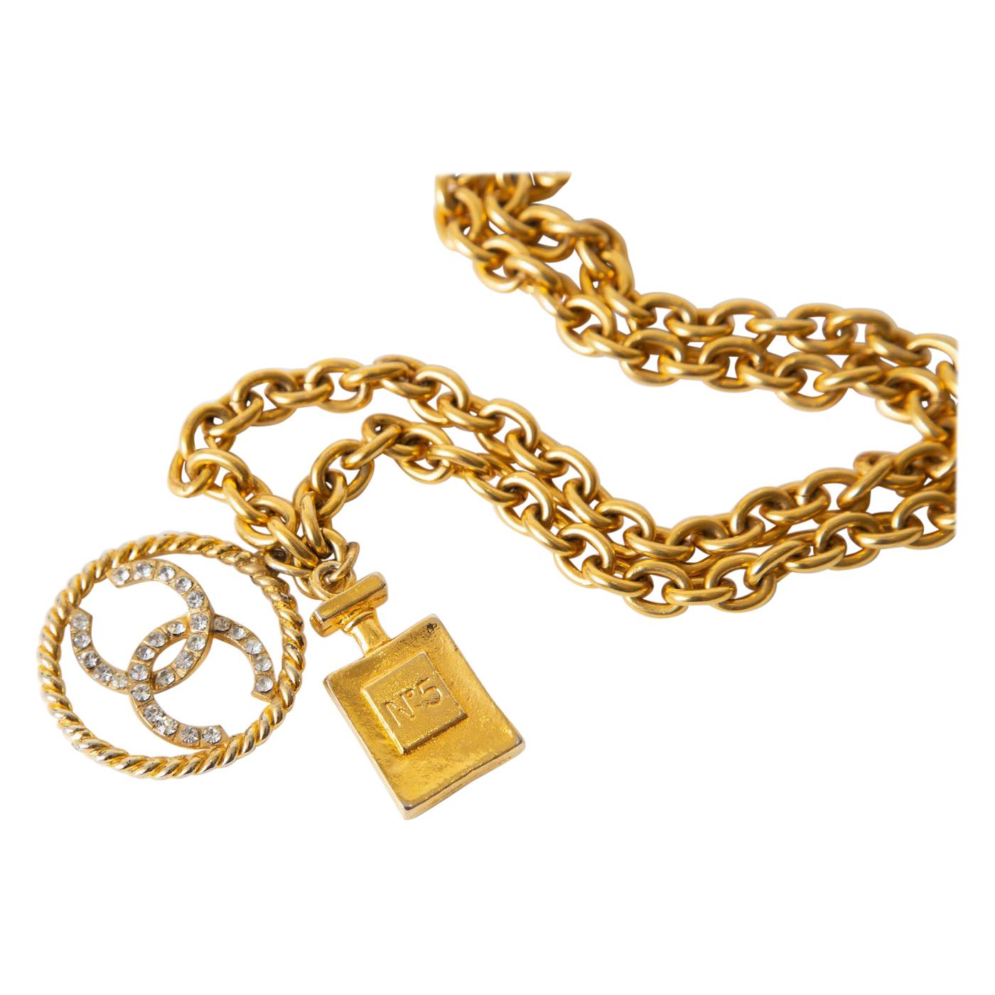 This Chanel 1980's chain link necklace is long and is pendant formed at the end with a circular CC''s of clear rhinestones and a dangled that says perfume # 5. One can go on top of another. It can be doubled on the neck to make more of a choker.