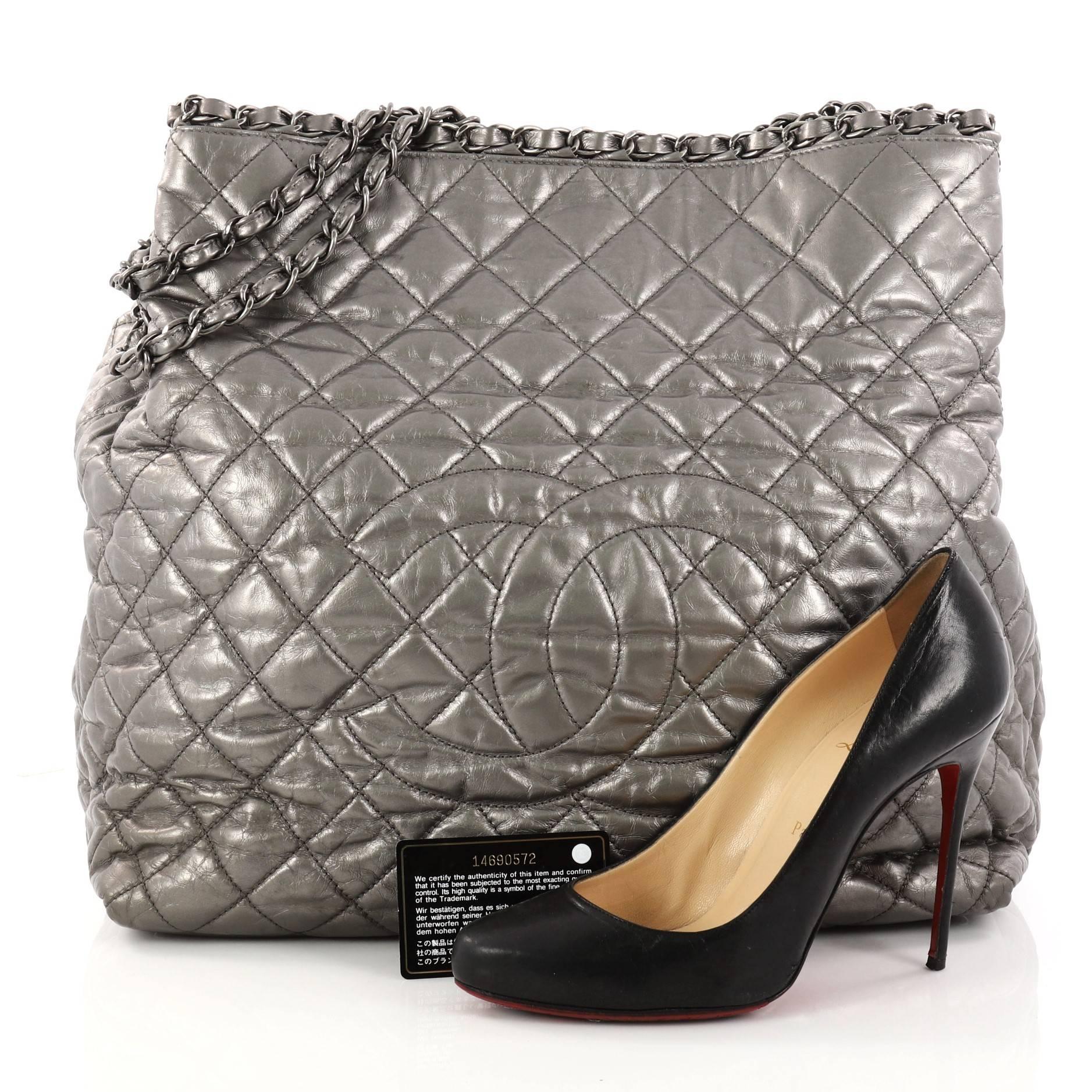 This authentic Chanel Chain Me Tote Quilted Calfskin Large showcases a modern classic design perfect for the on-the-go woman. Beautifully crafted from diamond quilted silver metallic calfskin leather, this stunning tote features woven-in leather