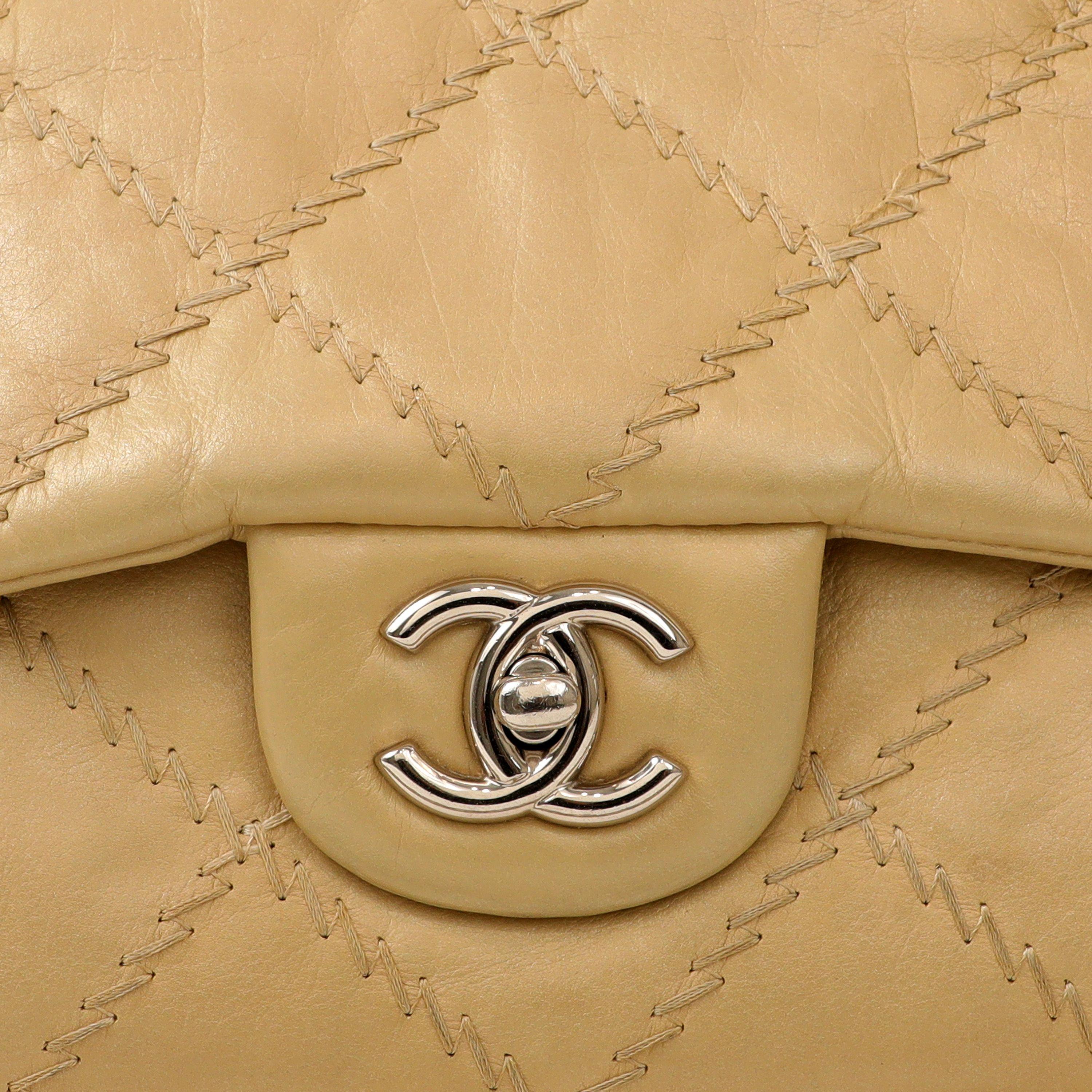 This authentic Chanel Champagne Gold East West Ultra Stitch Bag is pristine.  Perfectly warm and neutral champagne leather is top stitched in raised ultra stitch diamond pattern.  Silver interlocking CC twist lock secures the exterior flap. May be
