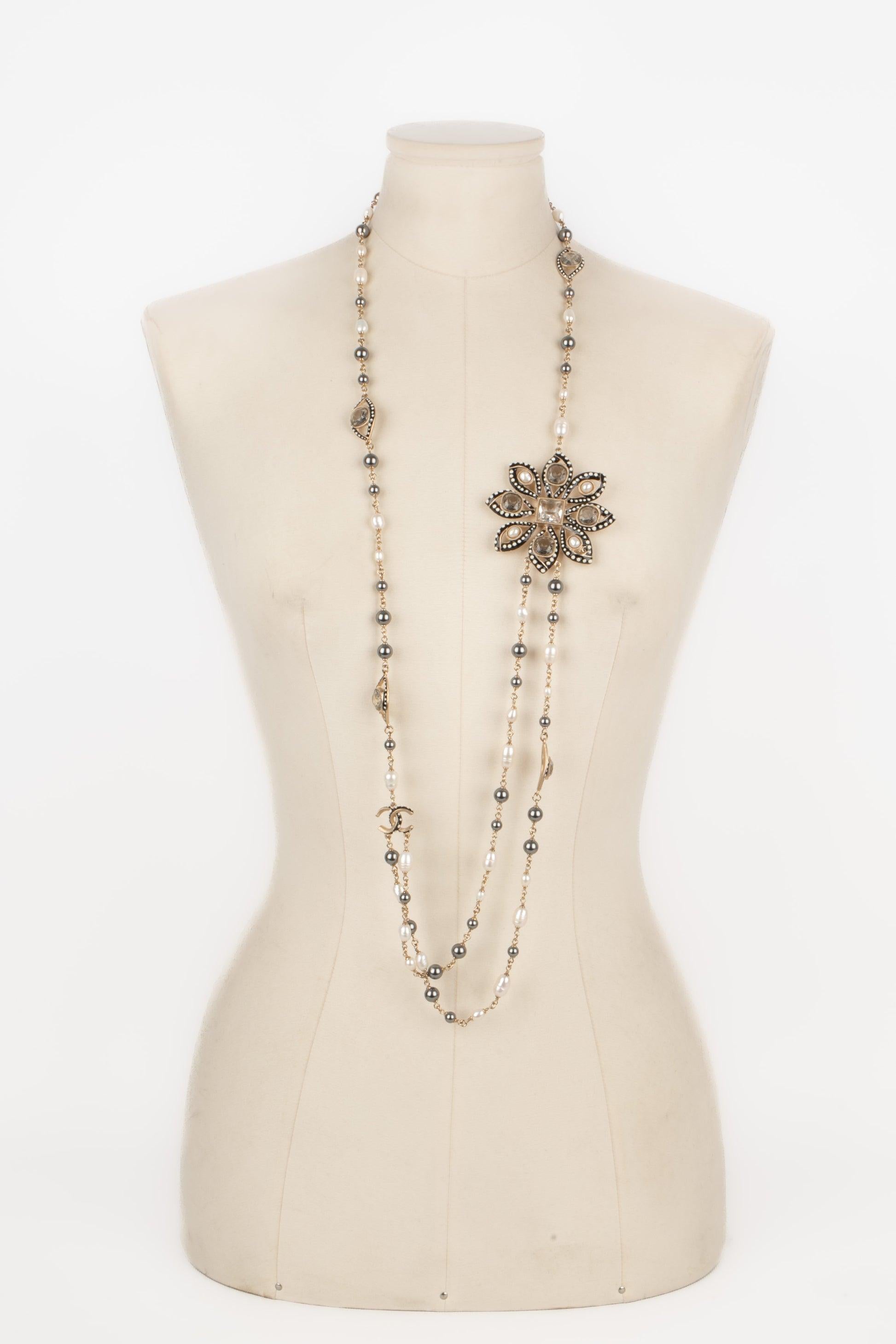 Chanel - (Made in France) Champagne metal necklace with freshwater pearls, and costume grey pearls. Enameled locket representing a flower. 2018 Collection.

Additional information:
Condition: Very good condition
Dimensions: Length: about 100