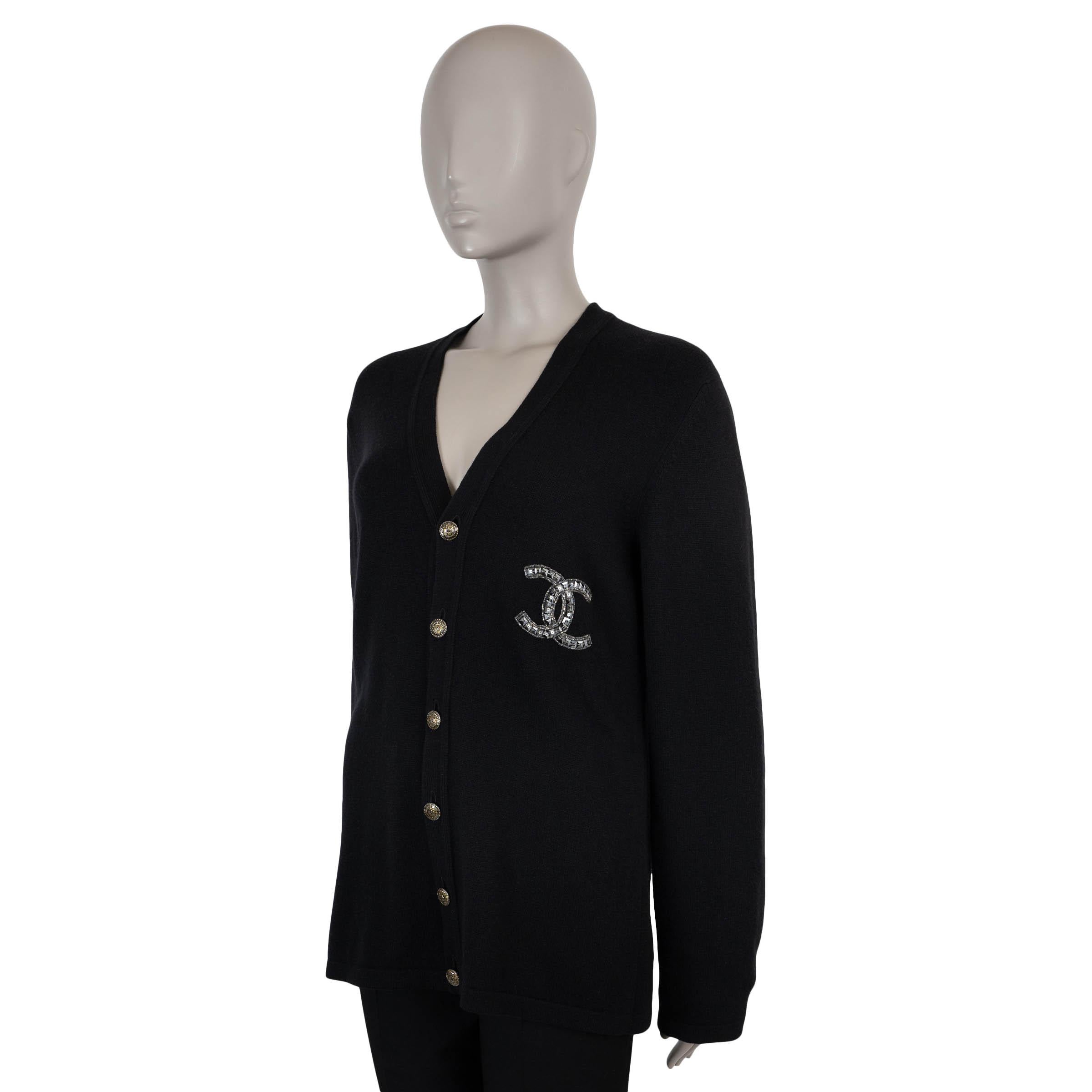 This 100% authentic Chanel cardigan is crafted in black cashmere for a soft and luxurious feel. The design features a V-neckline and a beaded and sequin CC logo on the chest for a touch of sparkle. It fastens with gold-tone metal buttons on the