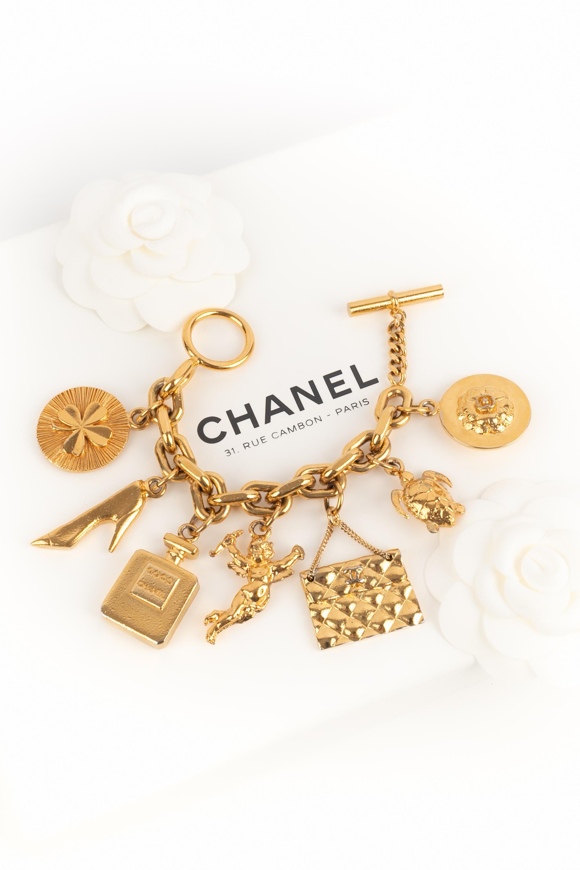 CHANEL - (Made in France) Golden metal bracelet with charms representing a stiletto shoe, a lucky clover, a handbag or even a camellia. Jewelry from the late 1980s.

Condition:
Very good condition

Dimensions:
Length: 19 cm

SKU:BRAB7