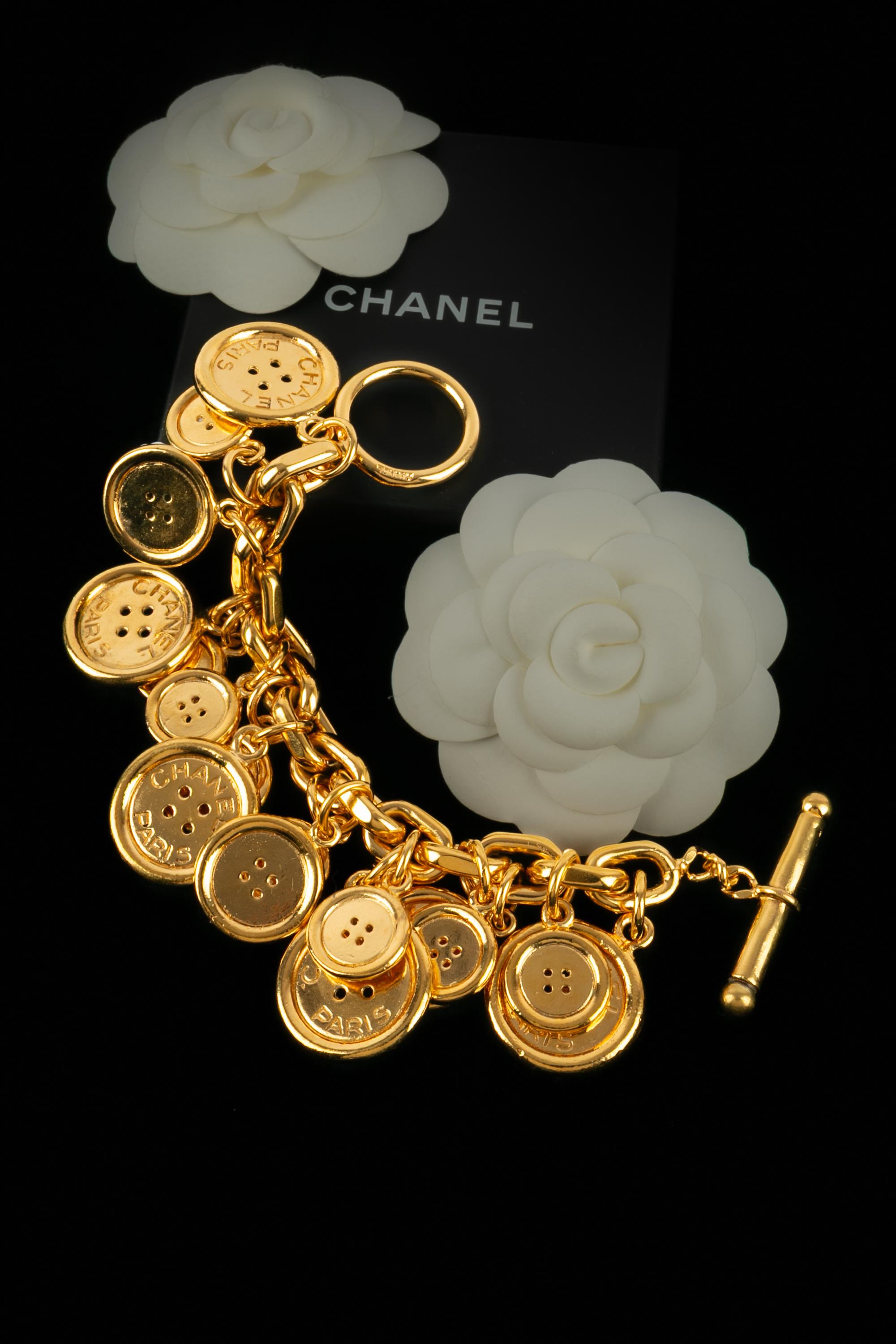 CHANEL - (Made in France) Golden metal charm bracelet with CHANEL engraved buttons. Jewelry from the early 1990s.

Condition:
Very good condition

Dimensions:
Length: 20 cm

SKU:BRAB6