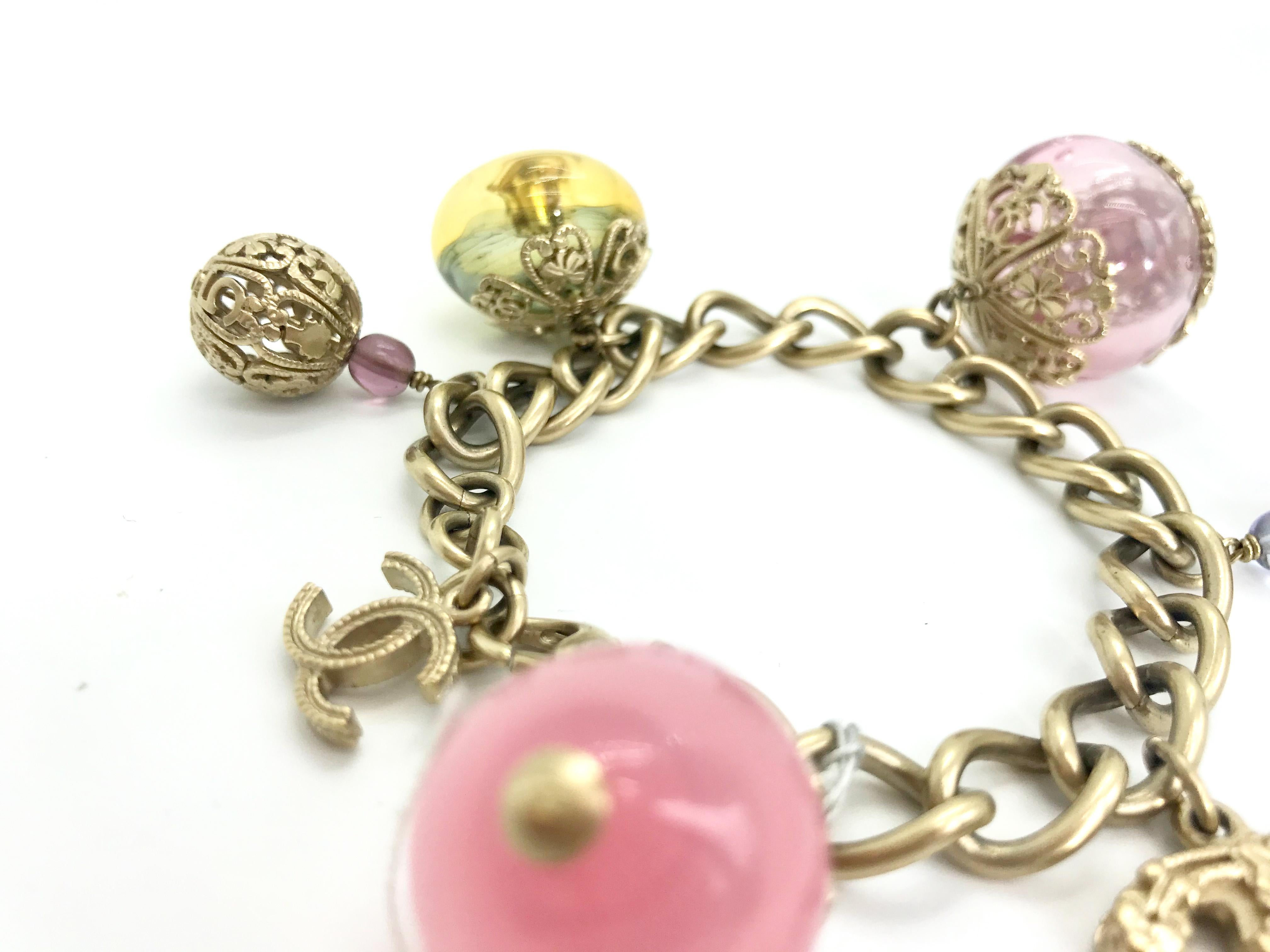 Brushed silver tone metal with pink and yellow toned glass globe charms, interlocking 'CC' logo detail and lobster clasp closure. From the Spring 2006 collection (marked on clasp).

Beautiful fine filigree detailing on the glass charms.  Features