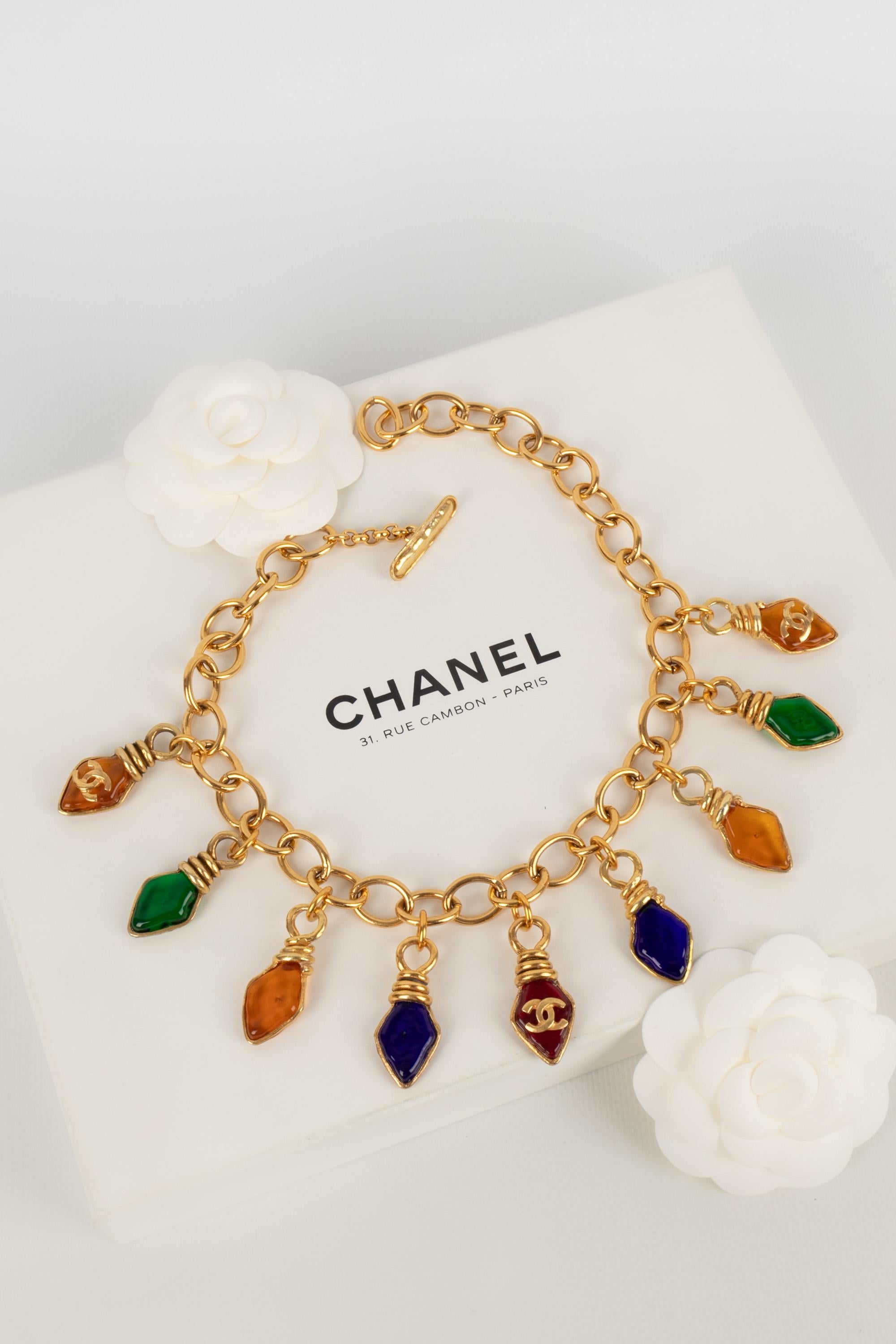 CHANEL - (Made in France) Golden metal short necklace with glass paste charms. 1995 Spring-Summer Ready-to-Wear Collection designed under the artistic direction of Karl Lagerfeld.

Condition:
Very good condition

Dimensions:
Length: about 44