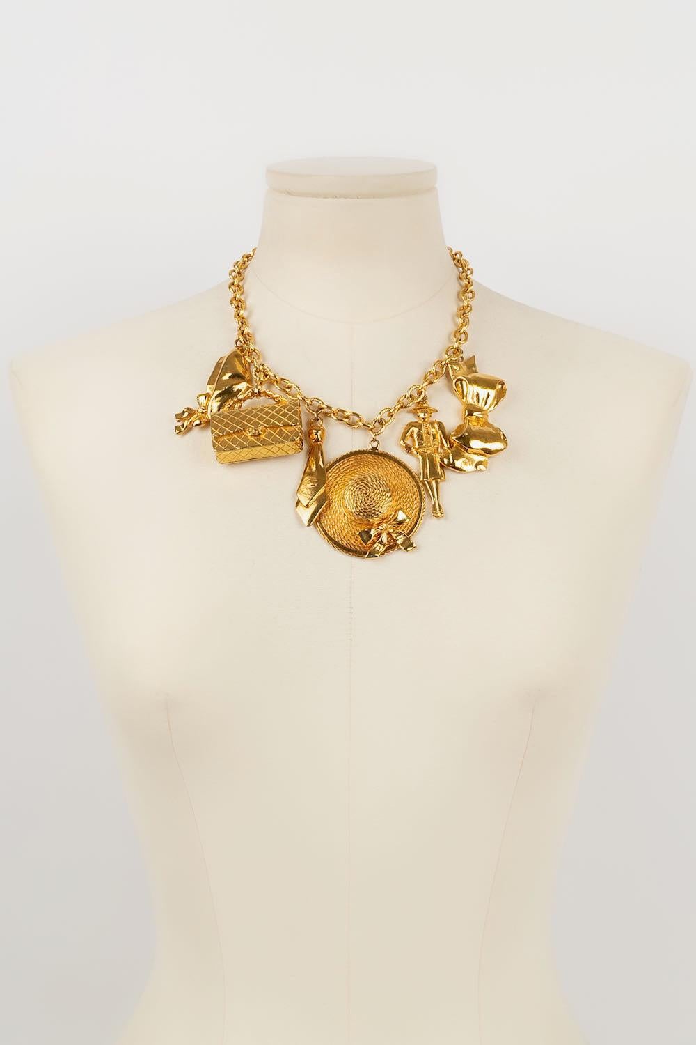 Chanel -(Made in France) Short gold metal necklace with charms featuring bags, bows and figurines.

Additional information: 
Dimensions: Length: 44 cm
Condition: Very good condition
Seller Ref number: CB80
