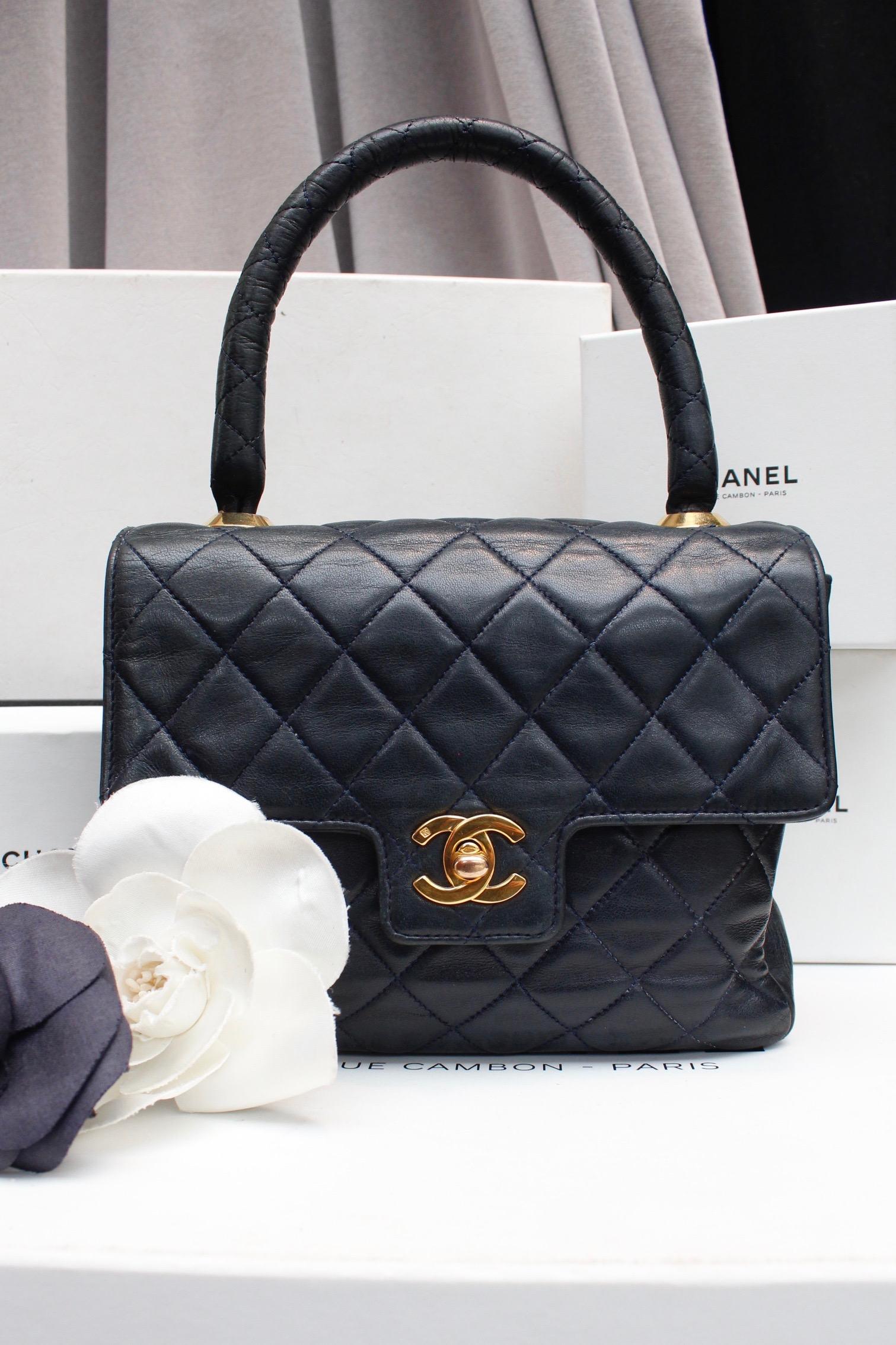 CHANEL – Charming little vintage handbag composed of quilted midnight blue lambskin. It features a quilted leather handle linked to the bag with two gilded metal rivets. It opens with a gilded metal twist lock. Red and blue leather lining.

The