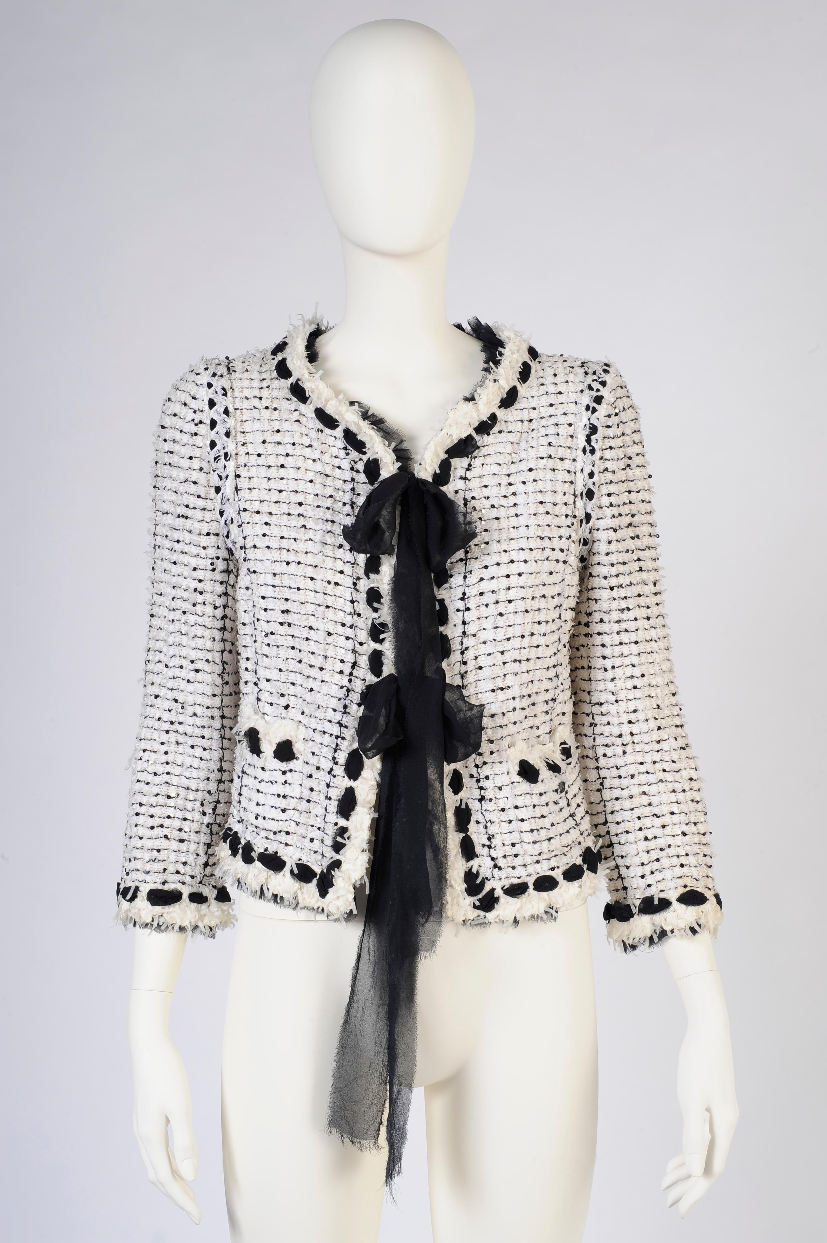 You can never go wrong with a little black and white jacket - especially when it's Chanel ! Unique combination of off-white wool, chenille and silk, the fabric is embellished with black threads and tiny sequins. Refined black silk chiffon ruffle all