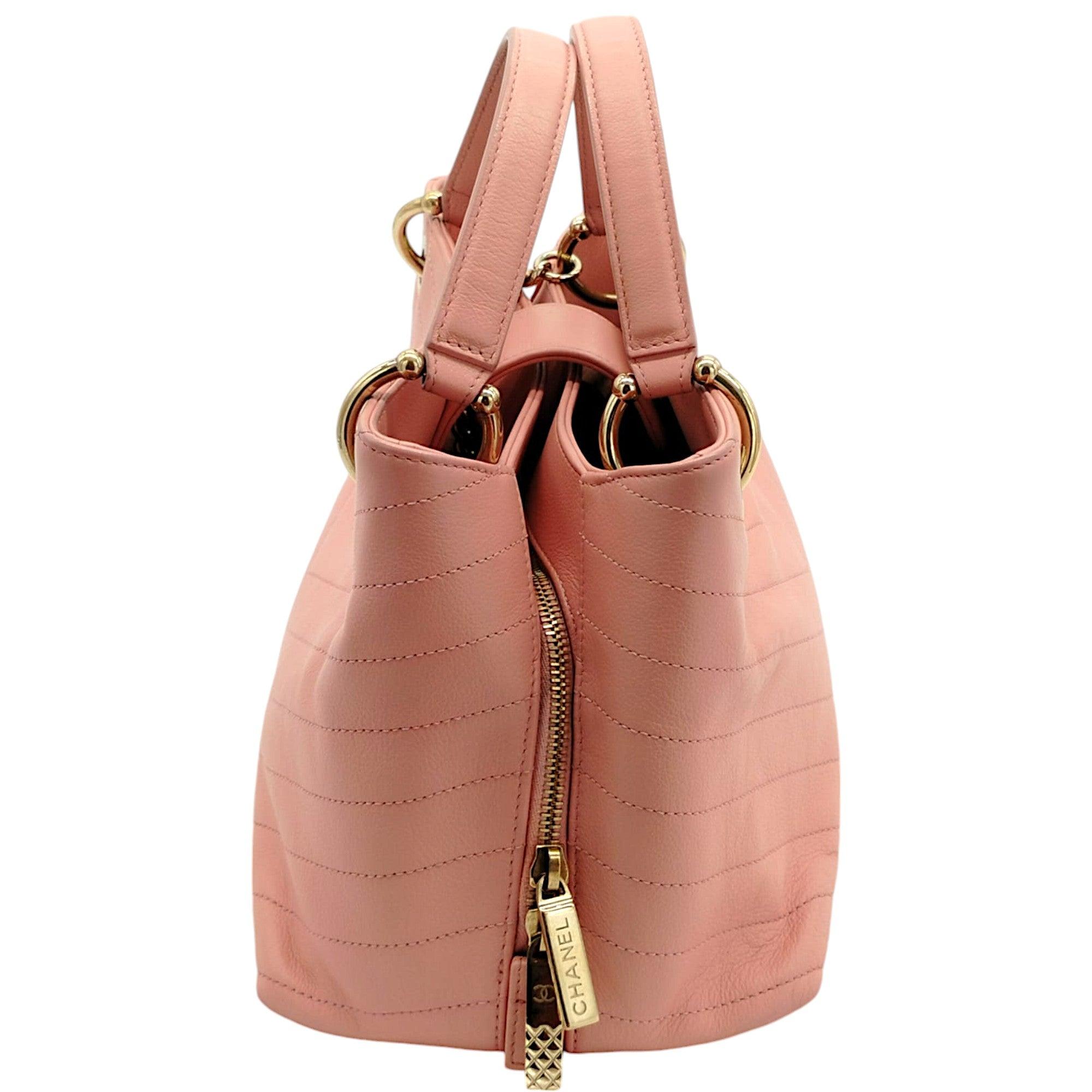 This refined tote is crafted from chevron-stitched textured calfskin leather in ivory. It features a durable top handle and an adjustable shoulder strap for versatile carrying options. The flap opens to reveal a tonal ivory fabric-lined interior,