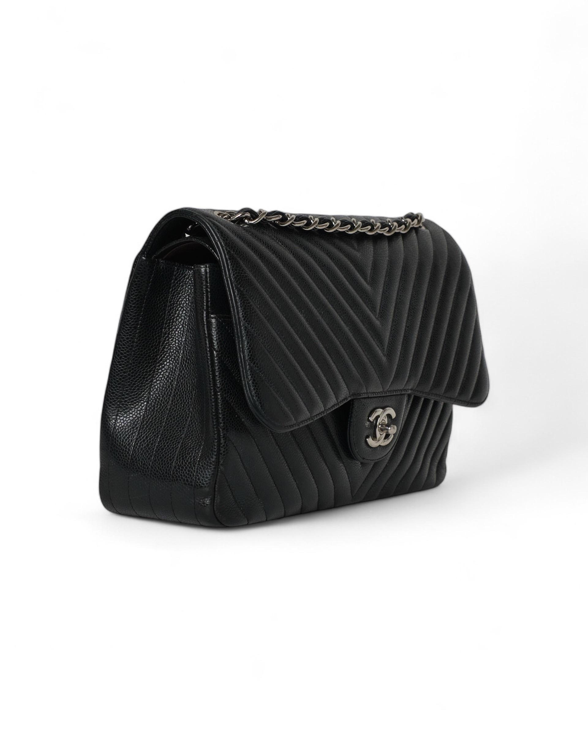 Borsa firmata Chanel, modello Chevron, misura Jumbo, realizzata in pelle caviar nera con hardware argentati. Dotata di doppia patta, una superiore con chiusura a girello logo CC ed una interna con chiusura a bottone. Internamente rivestita in pelle