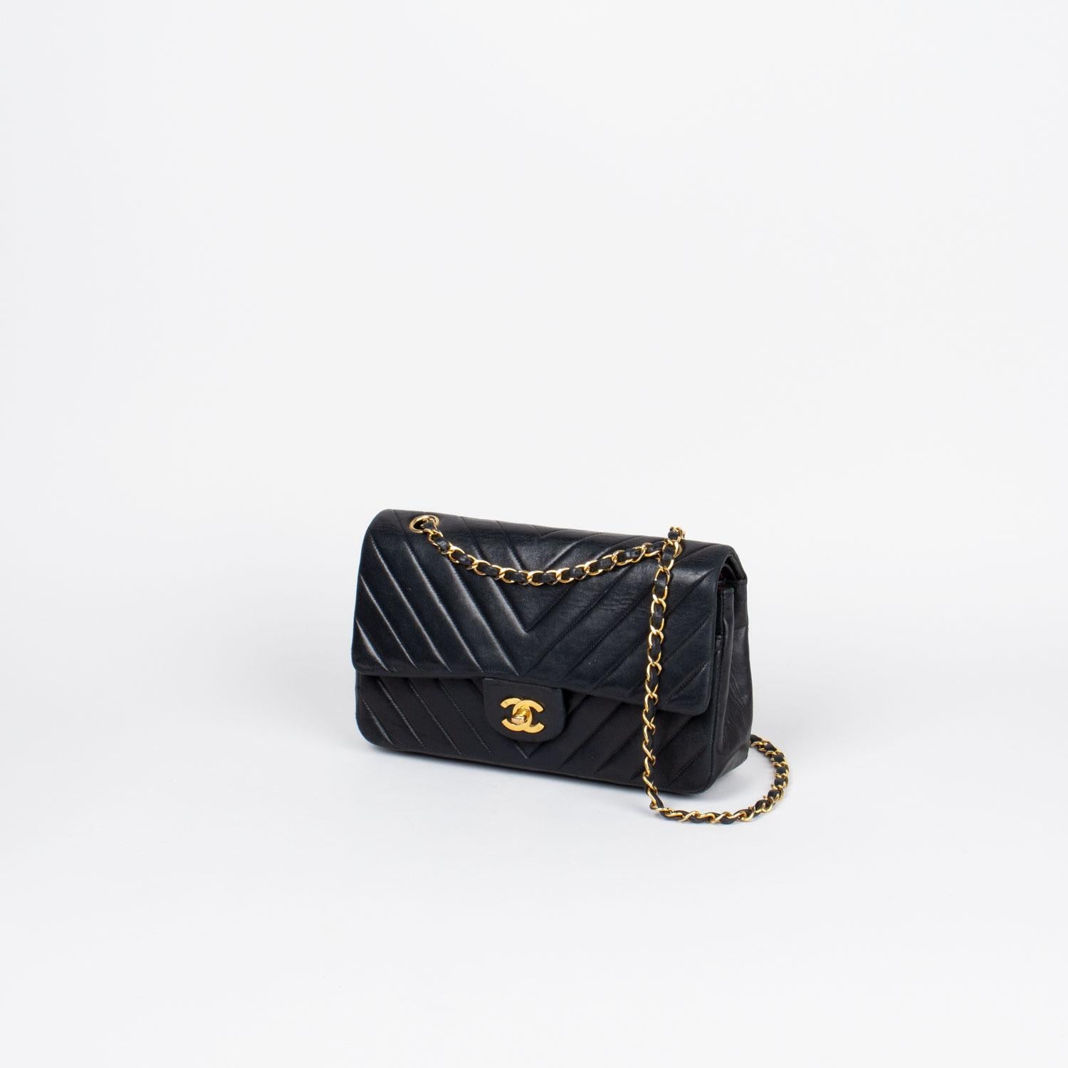 Black Chevron Quilted leather Chanel Medium Double Flap shoulder bag with

- Gold-tone hardware
- Single convertible chain-link and leather shoulder strap
- Single slit pocket at exterior wall, dual pockets at flap underside; one with zip closure,