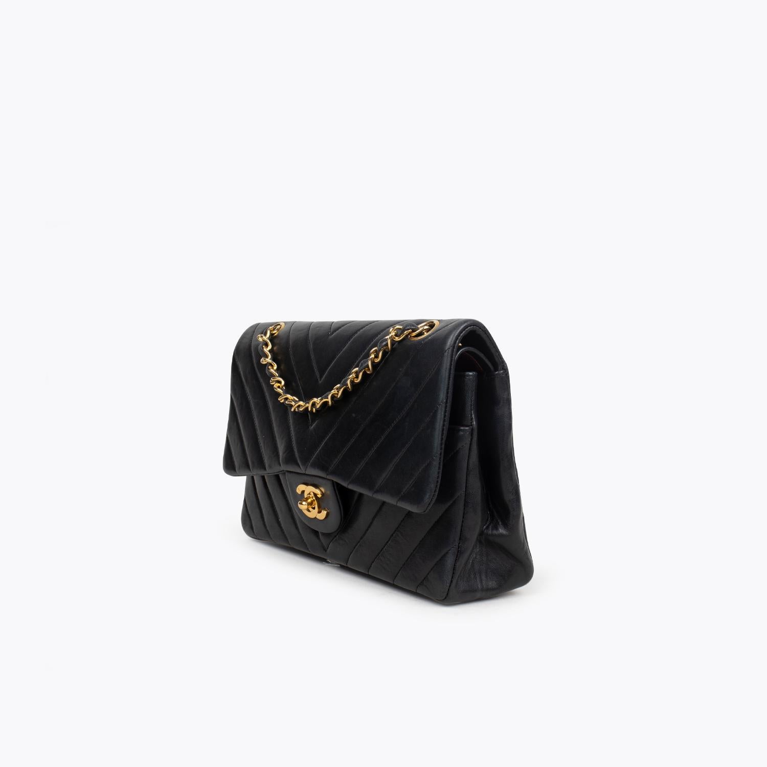 Black Chevron Quilted leather Chanel Medium Double Flap shoulder bag with

- Gold-tone hardware
- Single convertible chain-link and leather shoulder strap
- Single slit pocket at exterior wall, dual pockets at flap underside; one with zip closure,