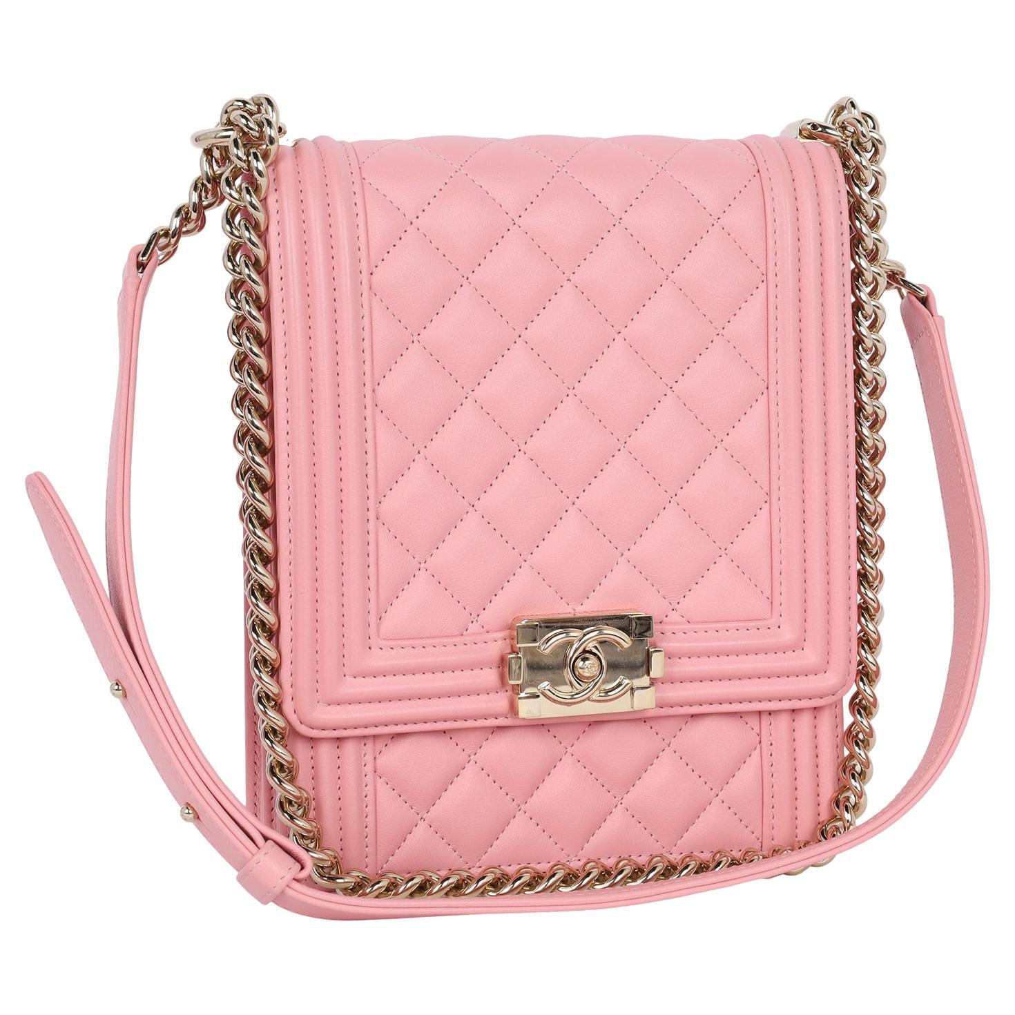 Auténtico bolso Chanel de segunda mano de piel de cordero acolchada Chevron Norte Sur Le Boy en rosa.

Presenta piel de cordero rosa chevron, gran cierre de presión con logotipo CC entrelazado, larga correa de cadena de eslabones dorada con piel