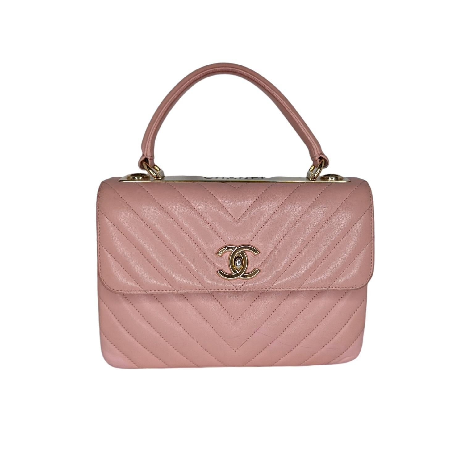This handbag is crafted of chevron quilted lambskin leather in light pink. This bag features a reinforced leather top handle with gold links, a gold chain leather threaded shoulder strap with a shoulder pad and a gold Chanel plate. The flap opens