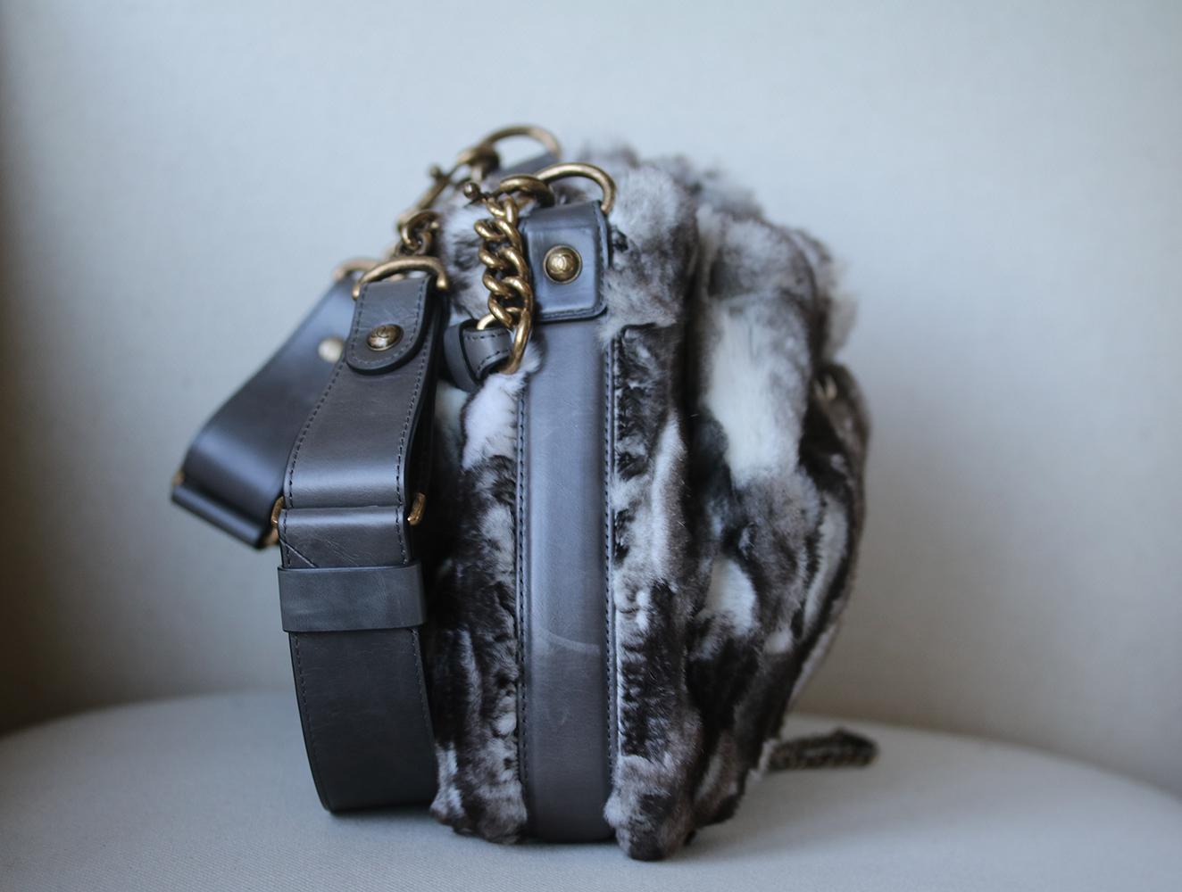 This super-chic shoulder and cross body bag is crafted in plush fur and leather accents. The bag features a bronze chain drawstring feature threaded through the opening of the bag. Chanel CC clasp push lock tightens the chain fastening. Grey leather