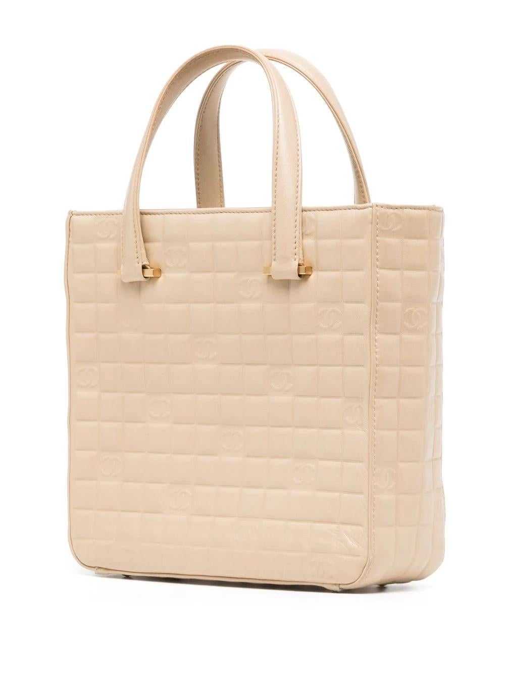 After the iconic interlocking CC logo, CHANEL’s diamond quilt is one of the brand’s most distinguishing features. Next in line is the Choco Bar quilt, displayed on this beige handbag in a small, symmetrical pattern of square-shaped stitching in