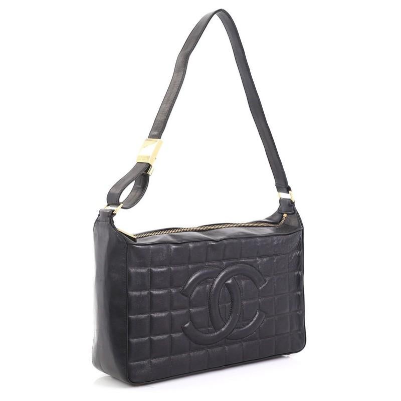 This Chanel Chocolate Bar CC Shoulder Bag Quilted Leather Medium, crafted in black quilted leather, features an adjustable leather shoulder strap, CC logo stitch at its center and gold-tone hardware. Its zip closure opens to a black fabric interior