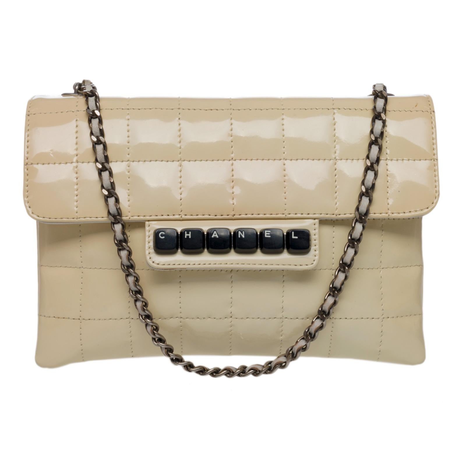 Wonderful Chanel Chocolate Bar Clavier handbag in beige quilted patent leather, hardware in silver metal, one chain strap in silver metal interwoven with white leather allowing the bag to be worn in the hand and on the shoulder

Flap closure,