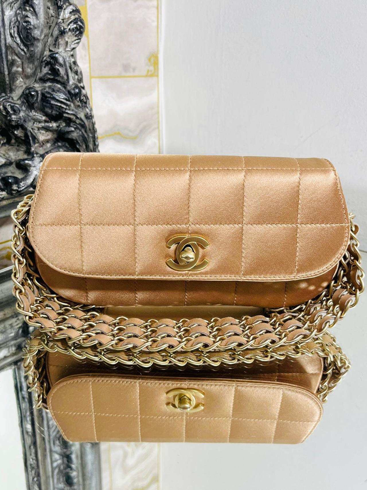 Chanel Chocolate Bar Five Chain Flap Bag

Peach tine satin bag with square stitch detailing and 'CC' twist lock closure.

Five rows of leather and chain trim and shoulder strap. From 2004/05.

Size - Height 10cm, Width 21cm, Depth 3.5cm

Condition -