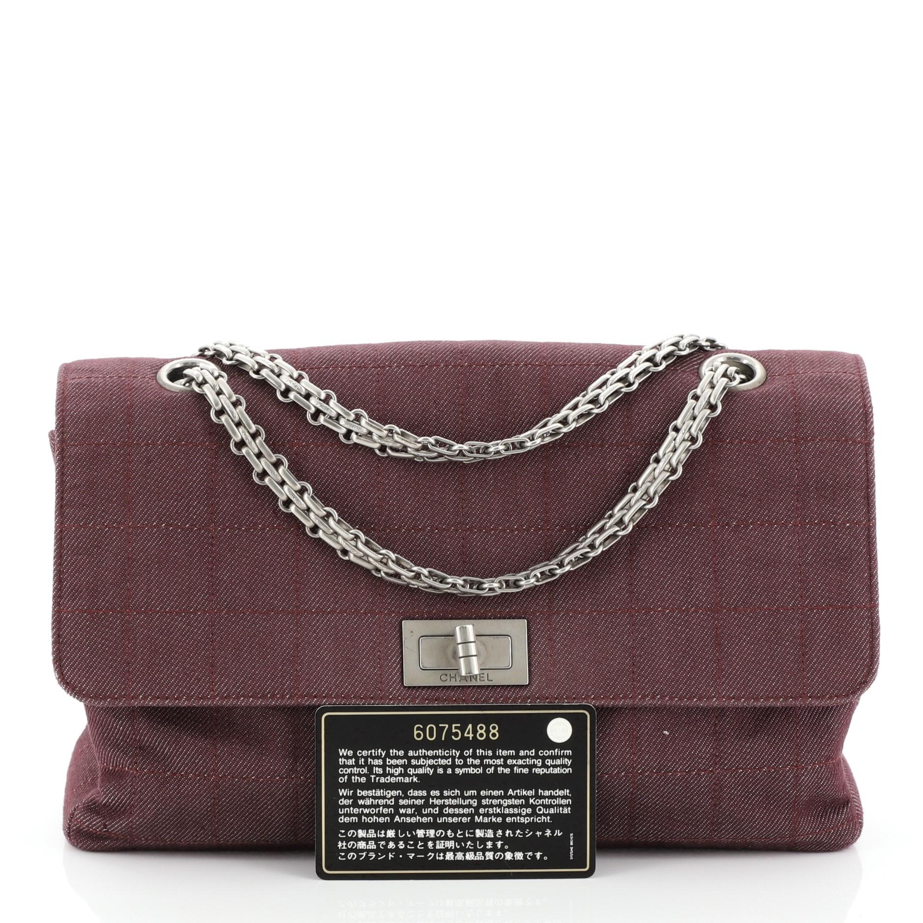 This Chanel Chocolate Bar Reissue Flap Bag Quilted Denim, crafted from red quilted denim, features reissue chain link strap and matte silver-tone hardware. Its mademoiselle turn-lock closure opens to a red fabric interior. Hologram sticker reads: