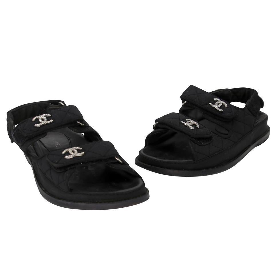 These Chanel sandals are simply to die for! They feature chic black quilted uppers and three straps with CC hardware. The wide strap style and heels provides added comfort for all day wear. Be the envy of the night with these dad sandals! The soles