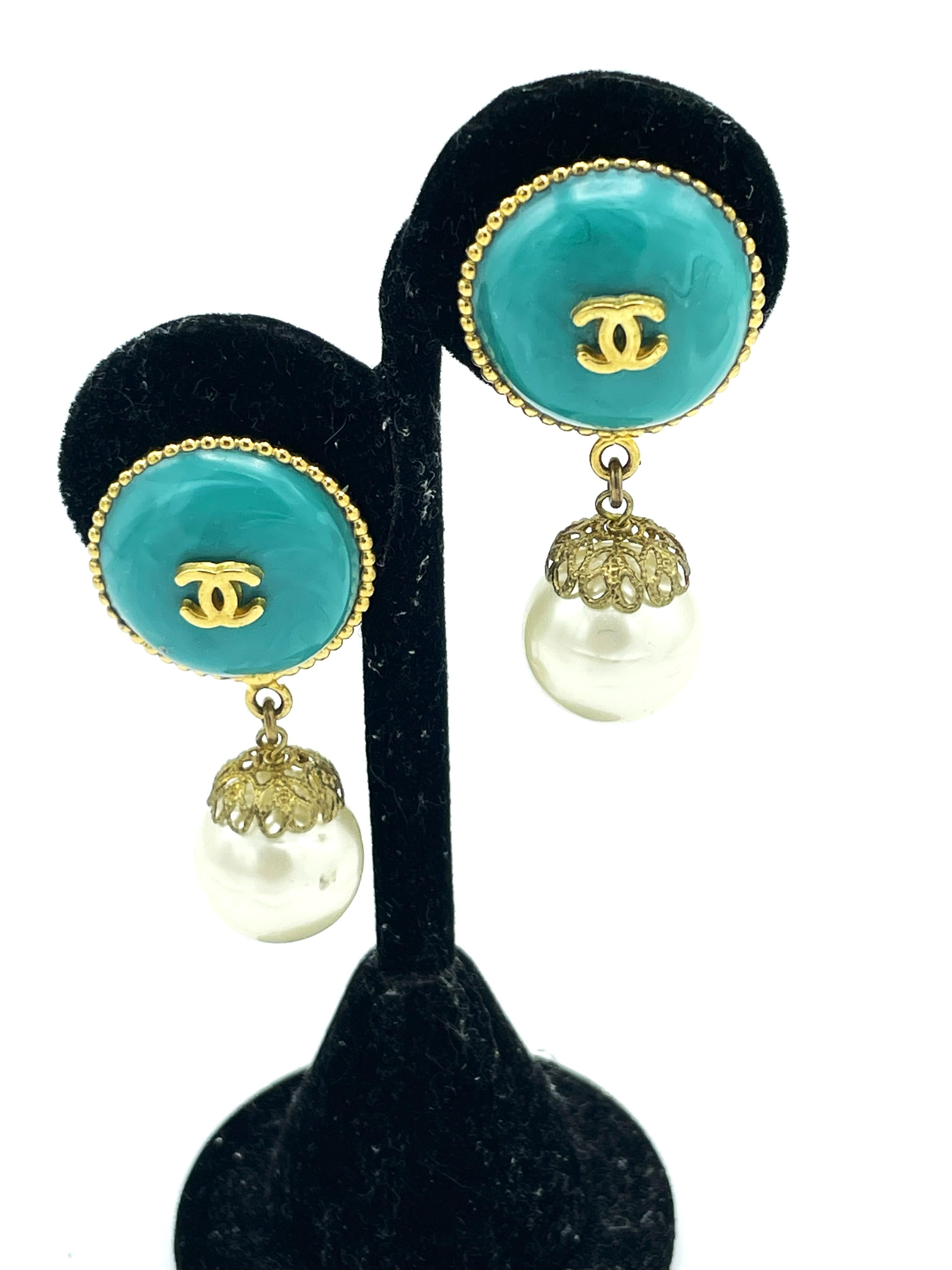 Chanel clip-on earring Paris (Made in France) singed 06 CC P - 2006 printemps.
Round türkis glass cabachon mith iconic CC. Handcrafted pearls. These summery earclips are in perfect condition and easy to wear. 

Dimensions:
Length  4,5 cm with
