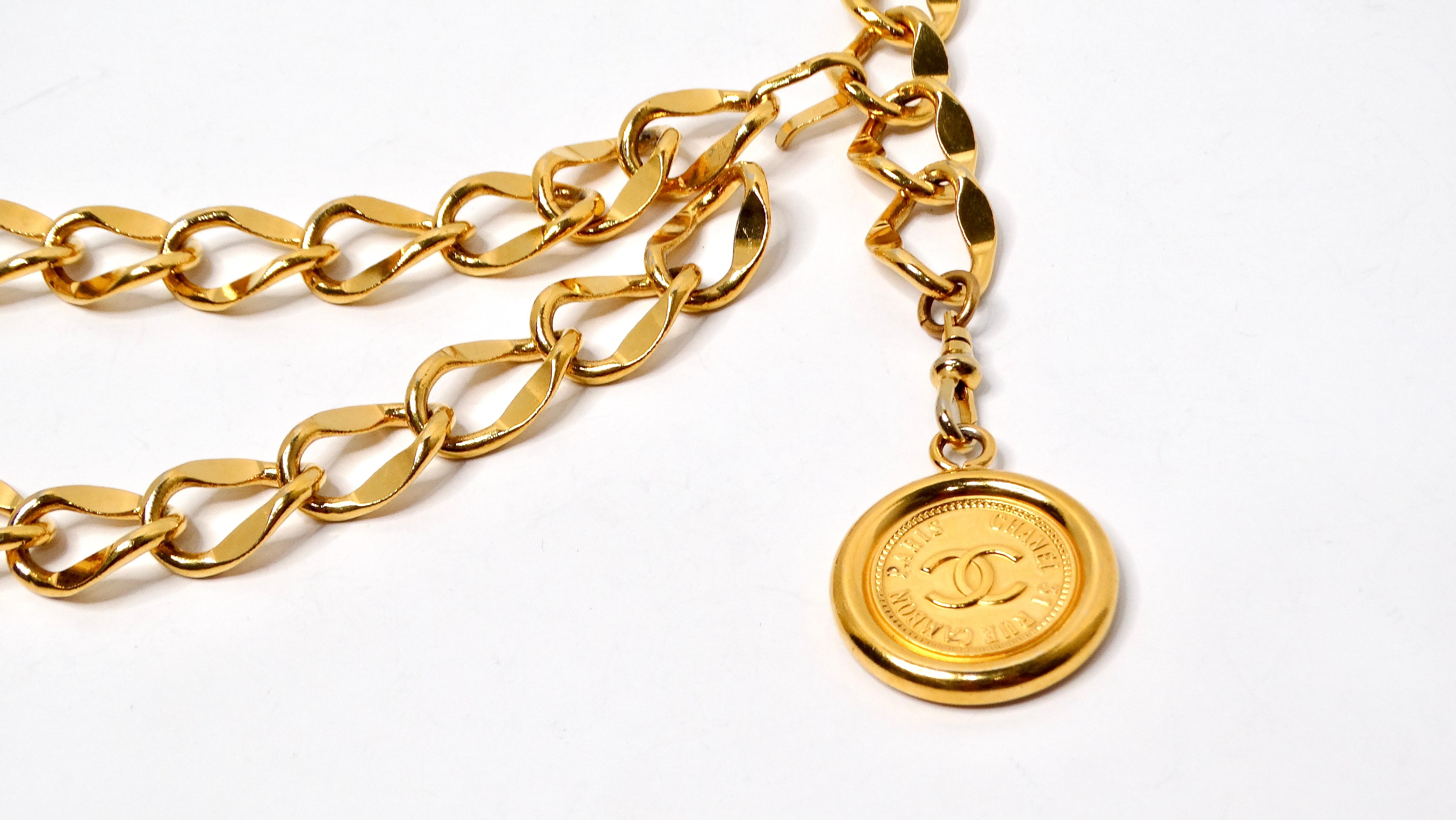 The Chanel Circa 1990s Gold-Tone Logo Medallion Chain Belt is an iconic statement piece that captures the spirit of high fashion and timeless luxury. This exquisite belt features a large loop chain design, characterized by its fluidity and stunning